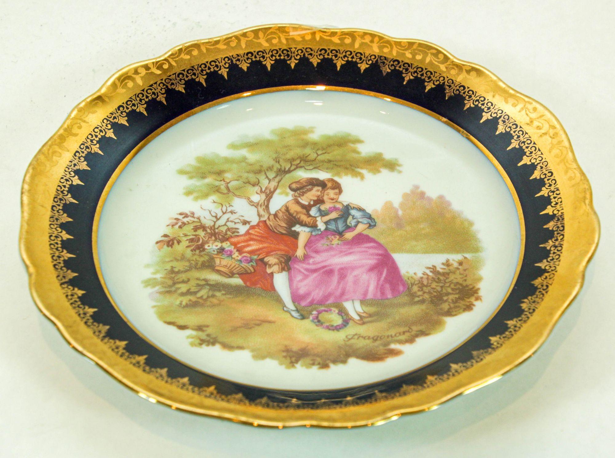 Vintage limoges Francia fina porcelana redonda decorativa azul y oro.
Elegante plato decorativo de porcelana fina pintado a mano con una romántica escena de amantes en un jardín, azul real cobalto y rico dorado en toda la superficie, según la