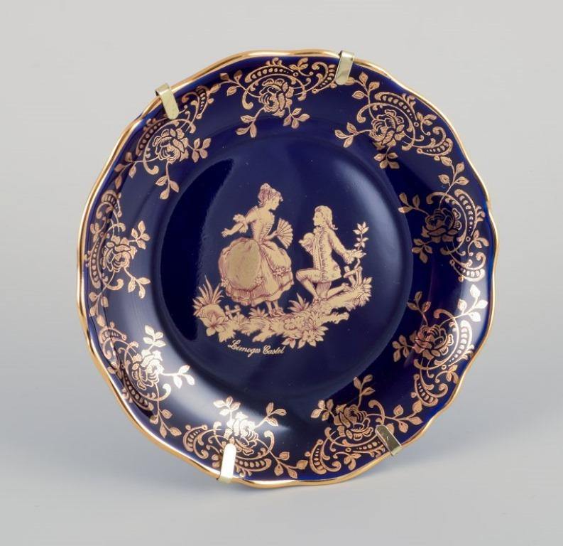 Limoges, France. Five pieces of porcelain including small trays and bowls, decorated with 22-karat gold leaf and a beautiful royal blue glaze. Scène galante. 
Approximately 1970.
Provenance: From a large French private collection of Limoges
