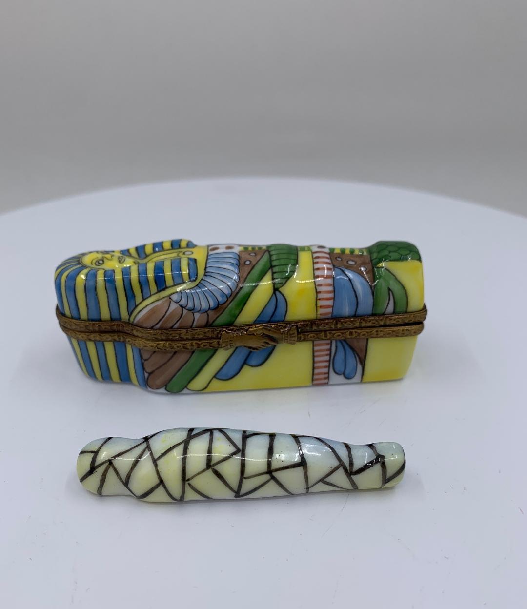 Collectible handmade and finely hand painted estate Limoges France porcelain miniature King Tutankhamun or King Tut sarcophagus shaped trinket box features a very detailed hand painted exterior. Open the box and inside reveals a hand painted