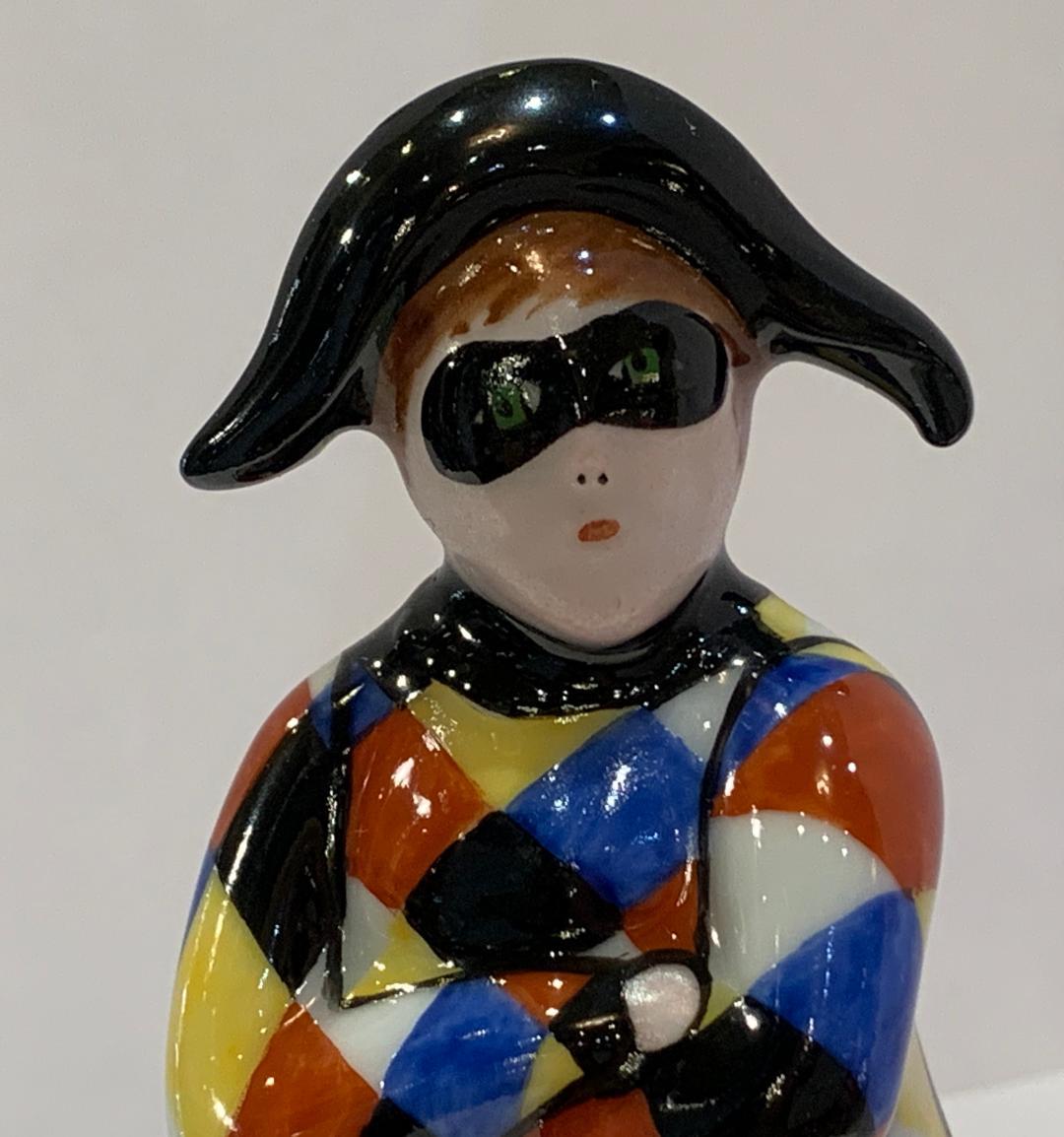Collectible handmade and finely hand painted estate Limoges porcelain miniature Harlequin or Arlequin shaped polychrome trinket box features a beautifully detailed hand painted exterior and antique gold tone metal fittings with a belt buckle shaped