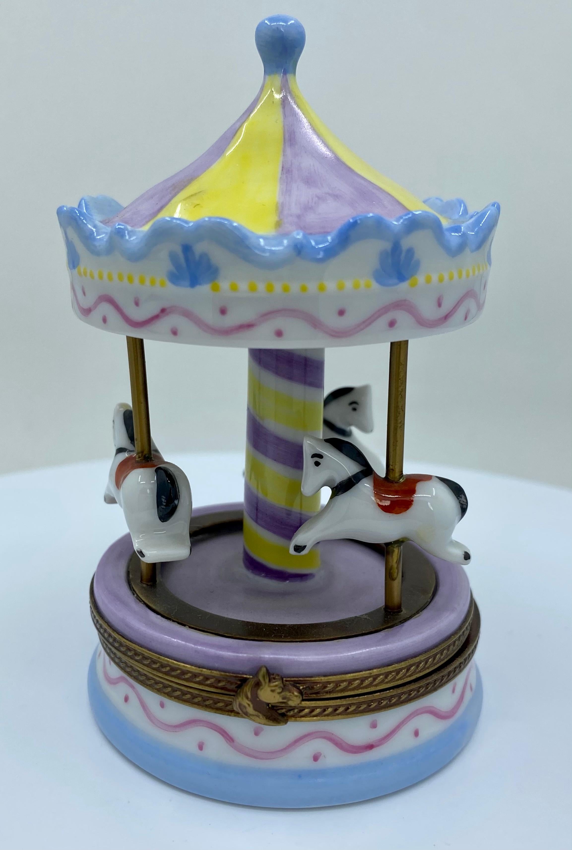 Collectible larger size Limoges porcelain miniature trinket box is handmade and hand painted in France. It features a merry- go-round carousel with three horses depicted in pretty pastel tones. Box opens up to reveal a hand painted music note