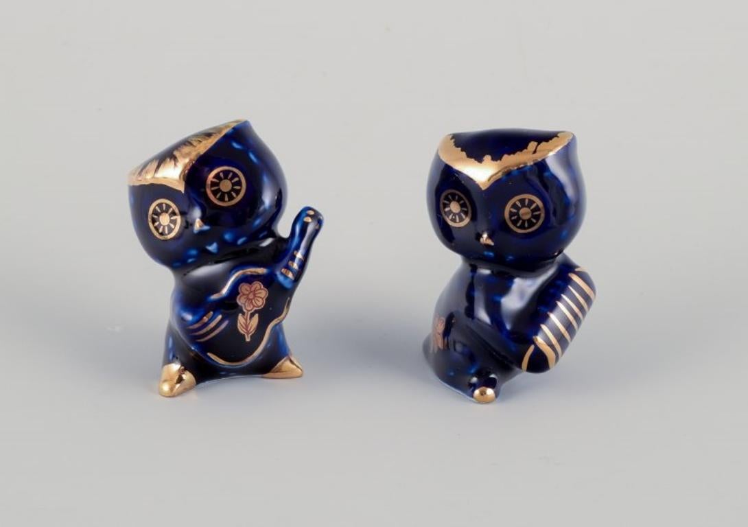 Limoges, Frankreich. Sieben Miniaturtiere aus Porzellan, verziert mit 22-karätigem Blattgold und einer schönen königsblauen Glasur. Galanter Schauplatz. 
Ungefähr 1970.
Provenienz: Aus einer großen französischen Privatsammlung von