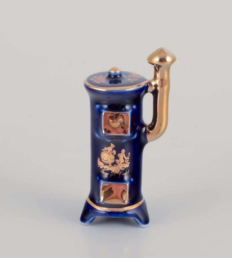 Limoges, Francia. Siete piezas de porcelana en miniatura, decoradas con pan de oro de 22 quilates y un hermoso esmalte azul real. Escena galante. 
Aproximadamente 1970.
Procedencia: Procedente de una gran colección privada francesa de porcelana de