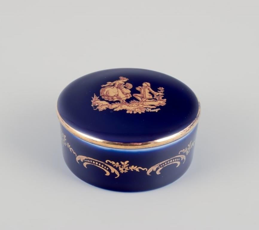 Limoges, Francia. Tres cajas/jarras con tapa en miniatura, de porcelana, decoradas con pan de oro de 22 quilates y un hermoso vidriado azul real. Escena galante. 
Aproximadamente 1970.
Procedencia: Procedente de una gran colección privada francesa