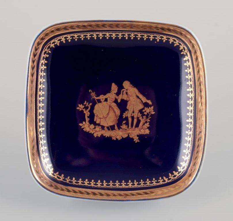 Limoges, France. Trois petits bols en porcelaine décorés de feuilles d'or 22 carats et d'une belle glaçure bleu royal. Scène galante.
Environ à partir de 1970.
Provenance : D'une grande collection privée française de porcelaine de
