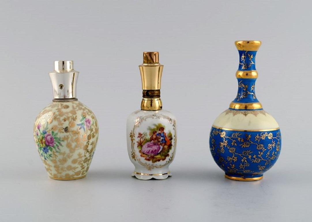 Peint à la main Limoges, France. Deux flacons de parfum, trois vases et une boîte à couvercle en porcelaine. en vente