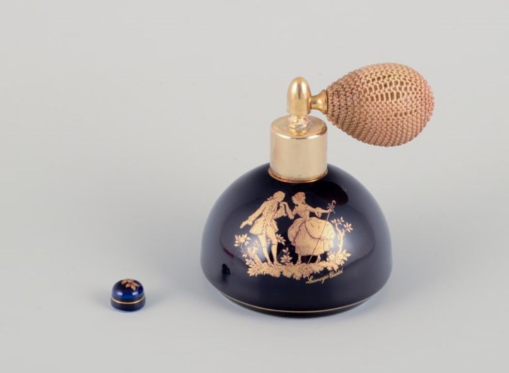 French Limoges, France. Two porcelain perfume atomizers and a makeup mirror