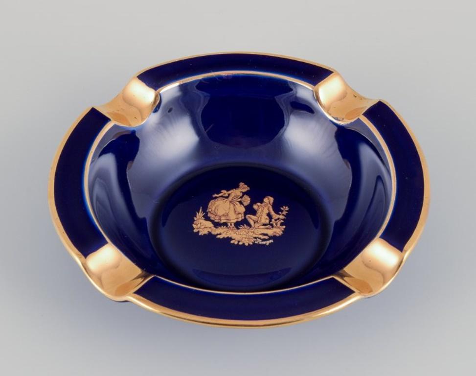 Limoges, Francia. Dos pequeños cuencos de porcelana decorados con pan de oro de 22 quilates y un hermoso vidriado azul real. Escena galante. 
Aproximadamente 1970.
Procedencia: Procedente de una gran colección privada francesa de porcelana de