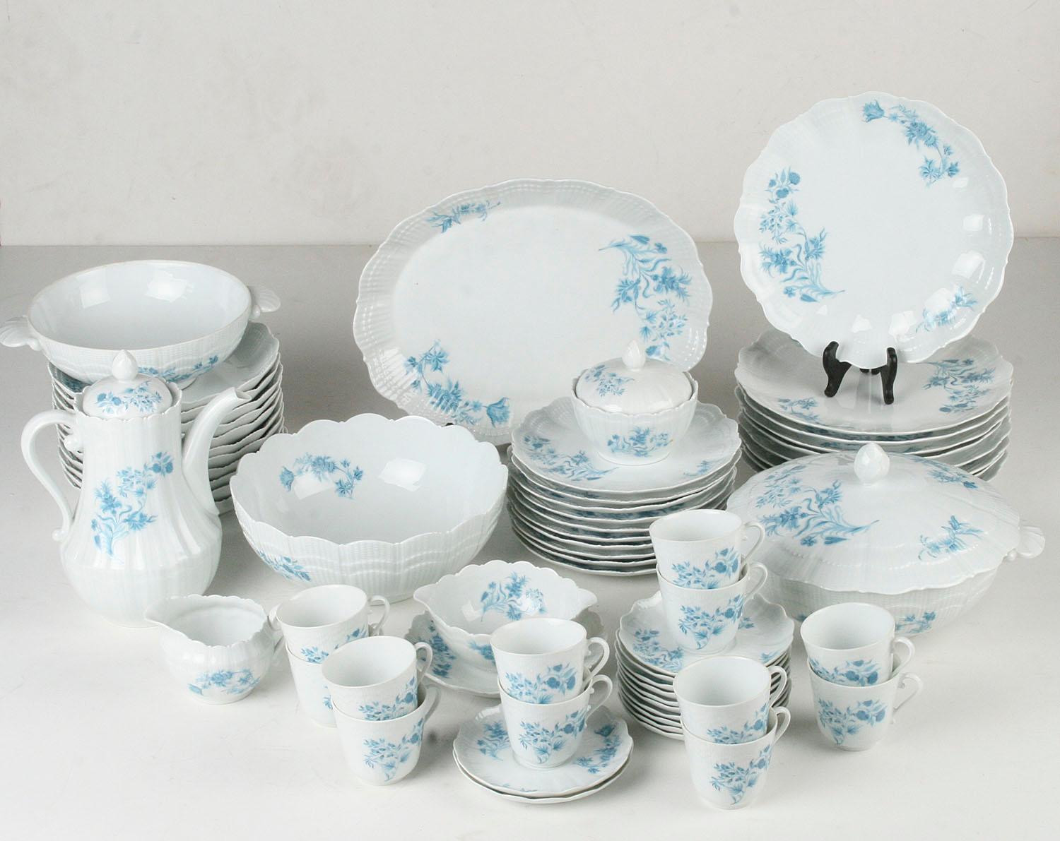 Beautiful set of porcelain dinner and tea ware, made by Giraud Limoges, France. 
The white porcelain is decorated with charming blue flowers. 
The set consist of the following pieces: 

10 breakfast plates Ø 20,5 cm 
12 cups and saucers, the