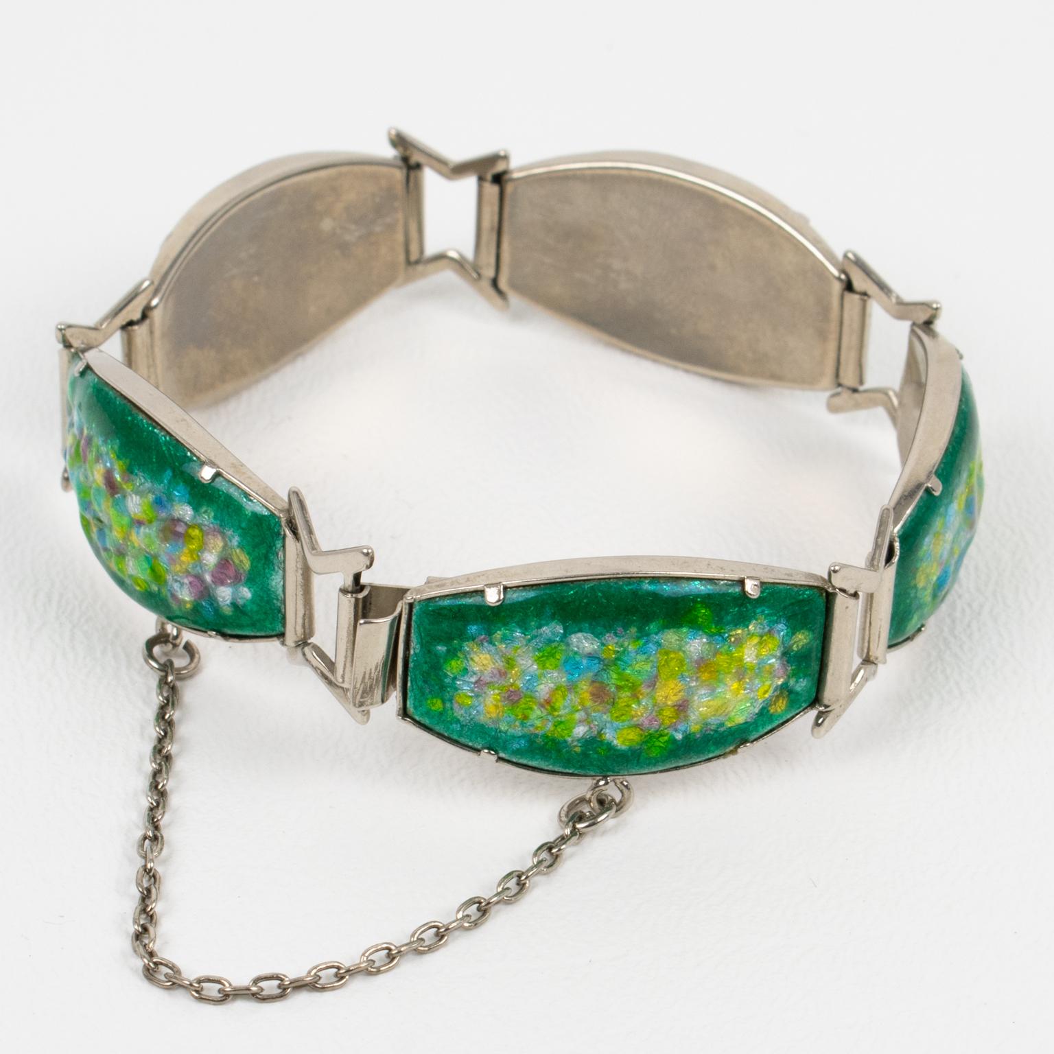 This link bracelet is a romantic piece featuring enamel and pate de verre. It was made in Limoges, France during the 1960s. The bangle boasts a chromed plated geometric framing topped with enameled domed ovoid copper elements. This popular 1950s and