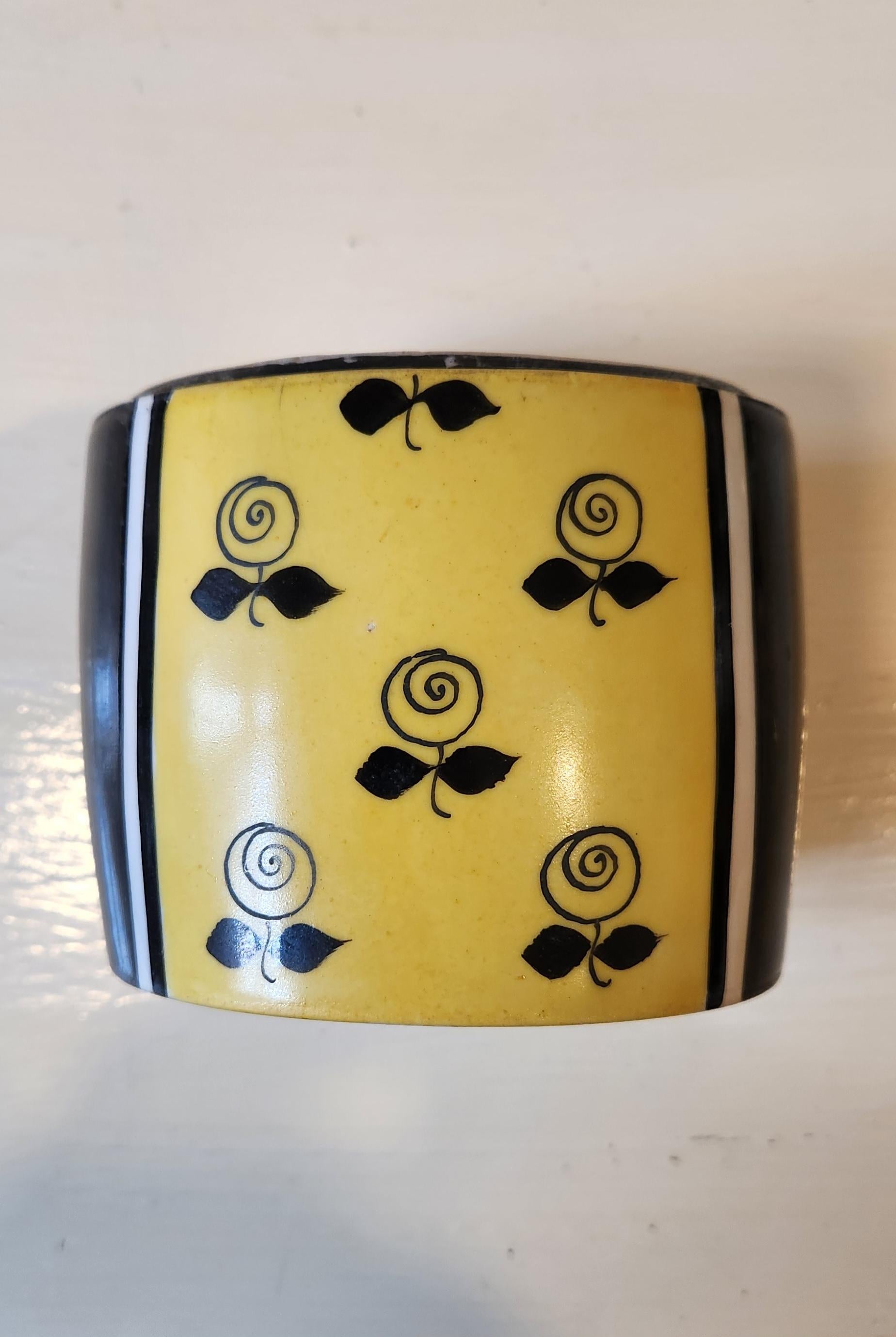This lovely powder box in an art deco style features a woman in a black and yellow patterned dress. The box is French porcelain, made and hand painted in Limoges. The marks are at the bottom of the piece, as well as inside of the top. There are