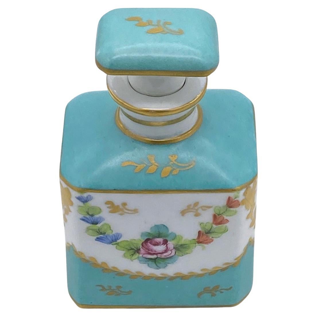 Dies ist ein Limoges Hand dekoriert Parfüm Flasche mit Stopfen. Diese türkisblaue Flasche auf weißem Hintergrund mit goldenen Strichen ist außerdem mit Rosen und Girlanden auf Vorder- und Rückseite verziert. Diese Porzellanflasche im französischen