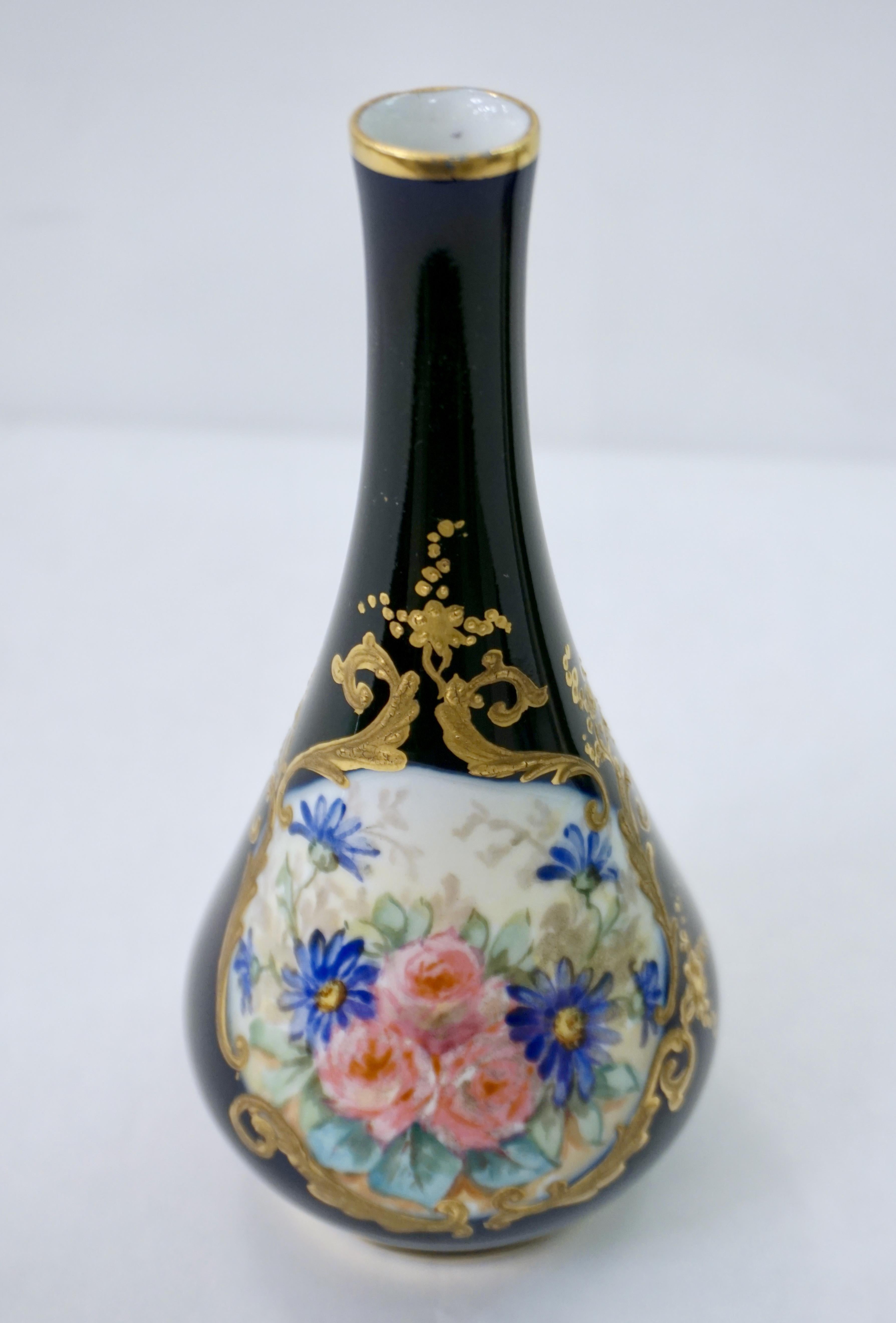 Early 20th century, French pair of small vases in Limoges porcelain, decorated each with a different front cameo hand painted with polychrome aqua blue, green, pink flowers on white background, with enamel relief accents painted in rich gold against