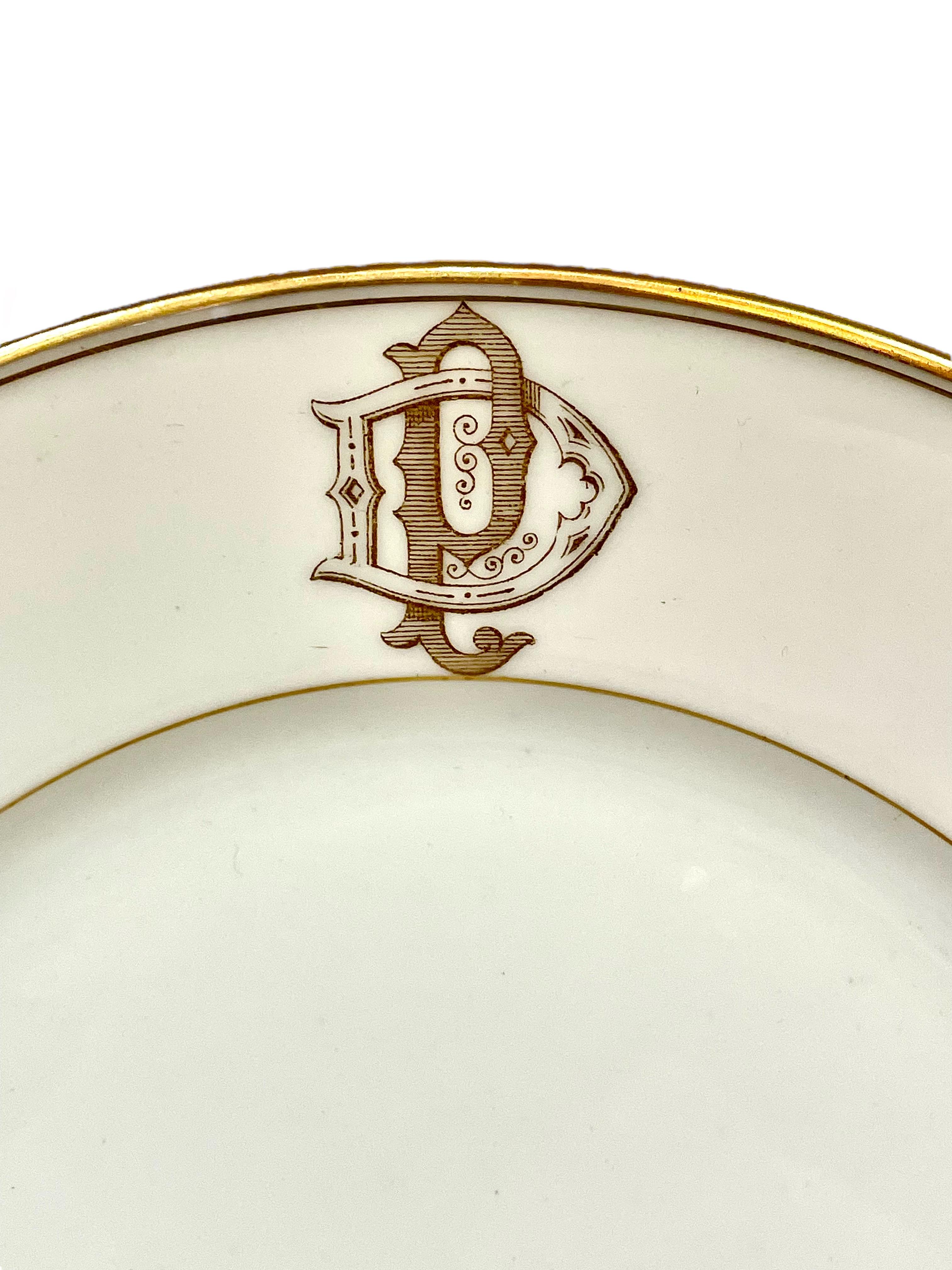 Un ensemble de 12 assiettes de style en porcelaine blanche délicate de Limoges, chaque pièce étant bordée d'une fine bordure dorée et portant le monogramme élaboré 'DP'. Datant de la fin du XIXe siècle, l'ensemble est en excellent état, avec une