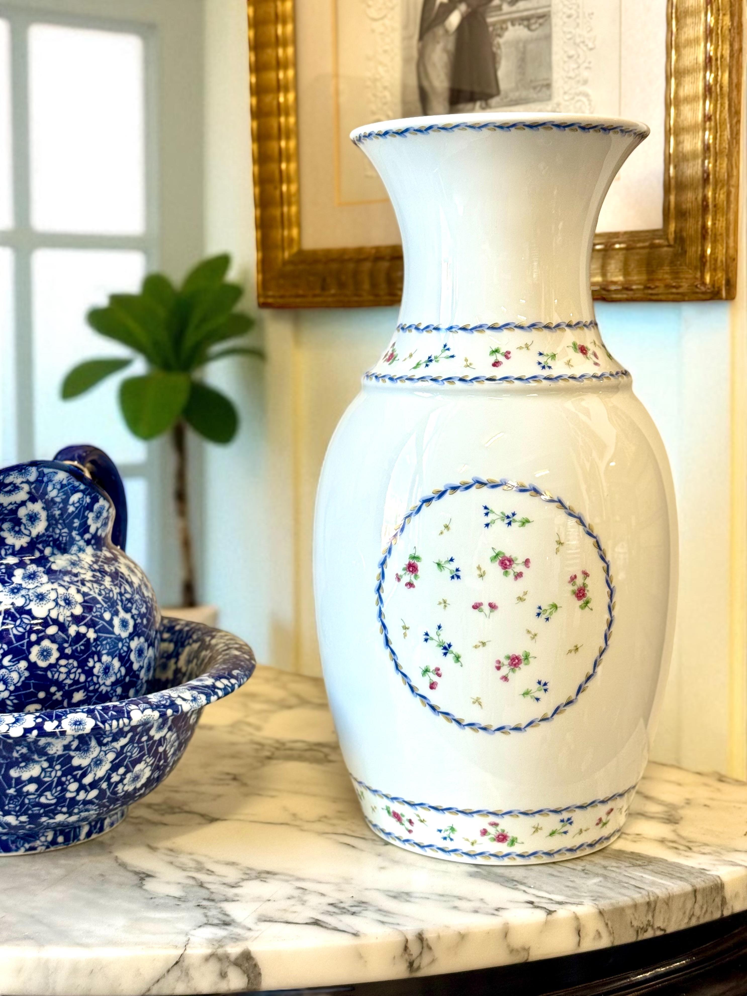 Este exquisito jarrón de porcelana francesa es obra de la renombrada manufactura Bernardaud de Limoges, y lleva el refinado motivo 