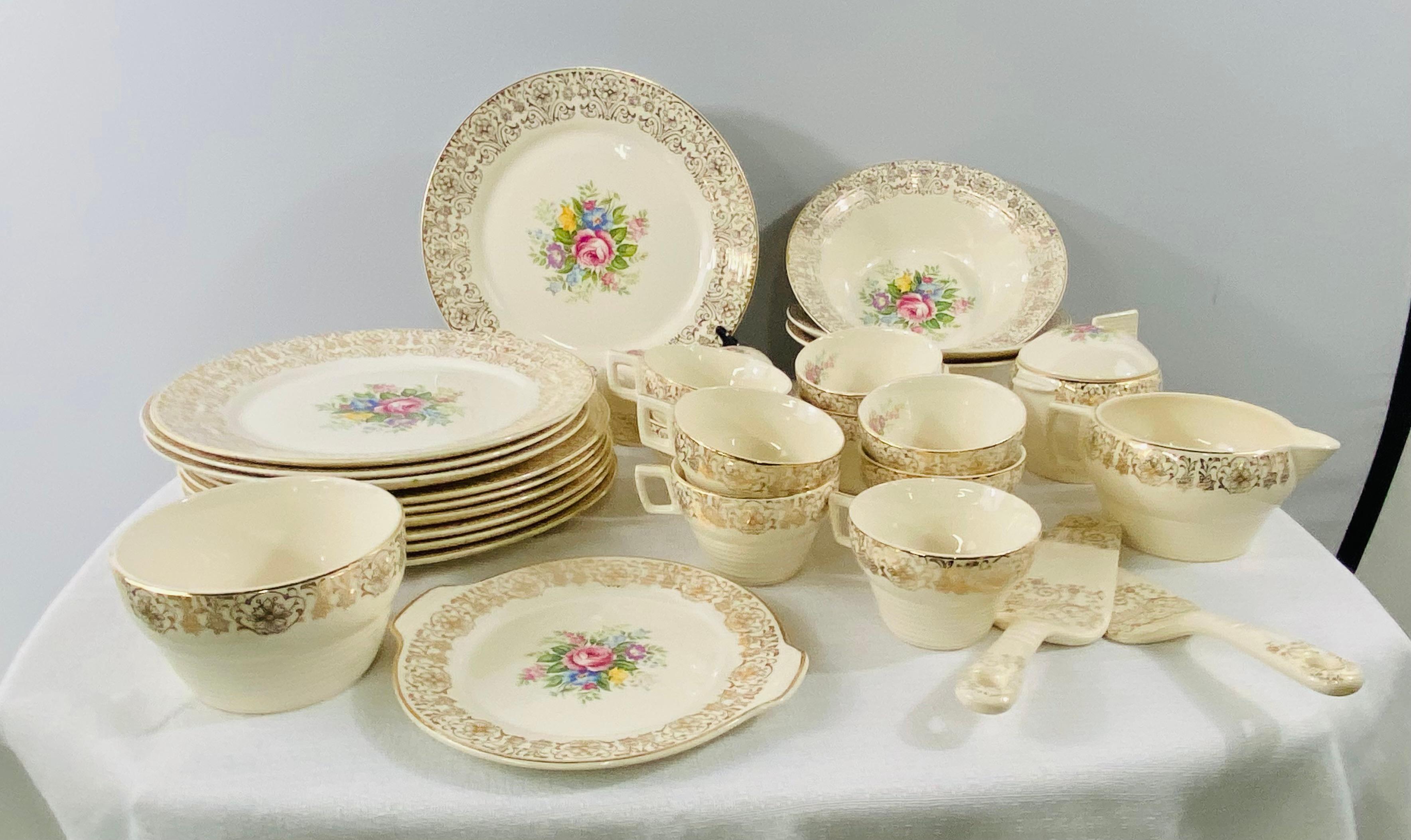 A timeless Limoges tableware set of 30 Pieces stamped Triumph, made in the USA Limoges Rosalie 1 T S 350-1 22 carat gold. Each piece is finely made of porcelain and hand painted in 22 carat gold with floral color design . The set is a mix of various