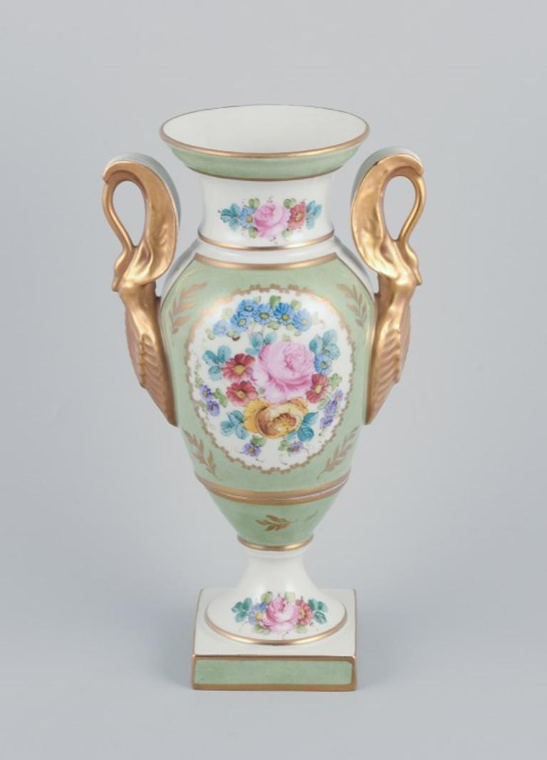 Limoges/Sevres, France. Porcelain vase on a pedestal, handles shaped like swans. 
Hand-decorated with polychrome floral motifs. Decorated by Mansard, Paris. Gold decoration. Empire age form.
Early 1900s.
Marked and signed.
In perfect