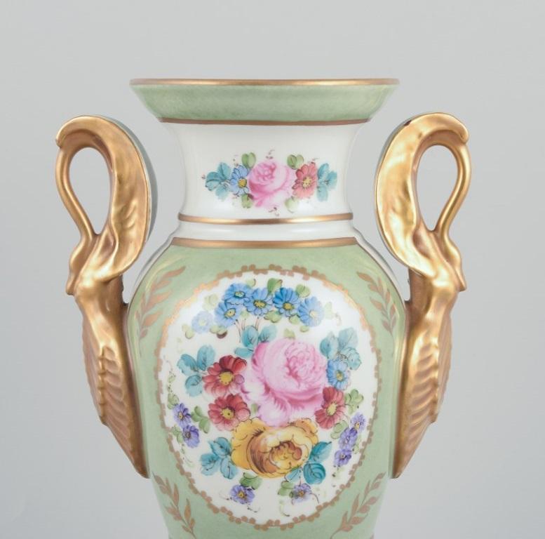 Empire Limoges/Sevres, France. Porcelain vase on a pedestal, handles shaped like swans.