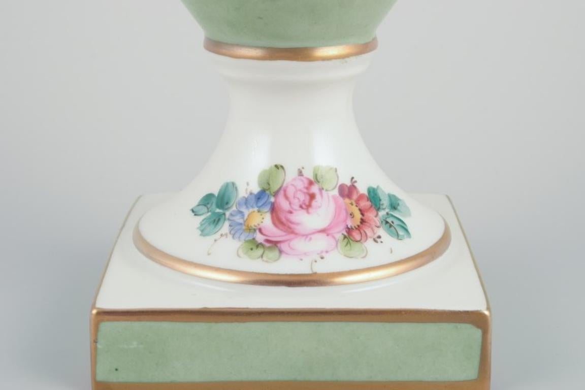 20th Century Limoges/Sevres, France. Porcelain vase on a pedestal, handles shaped like swans.