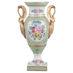 Limoges/Sevres, France. Porcelain vase on a pedestal, handles shaped like swans.