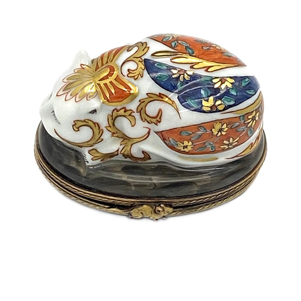 This is a Limoges trinket box chinoiserie cat. The detailed hand painted chinoiserie style porcelain cat has a brass frame and mouse clasp. He will peacefully crouch on on your vanity and be the best company.

Nouveau Boutiques does not just have