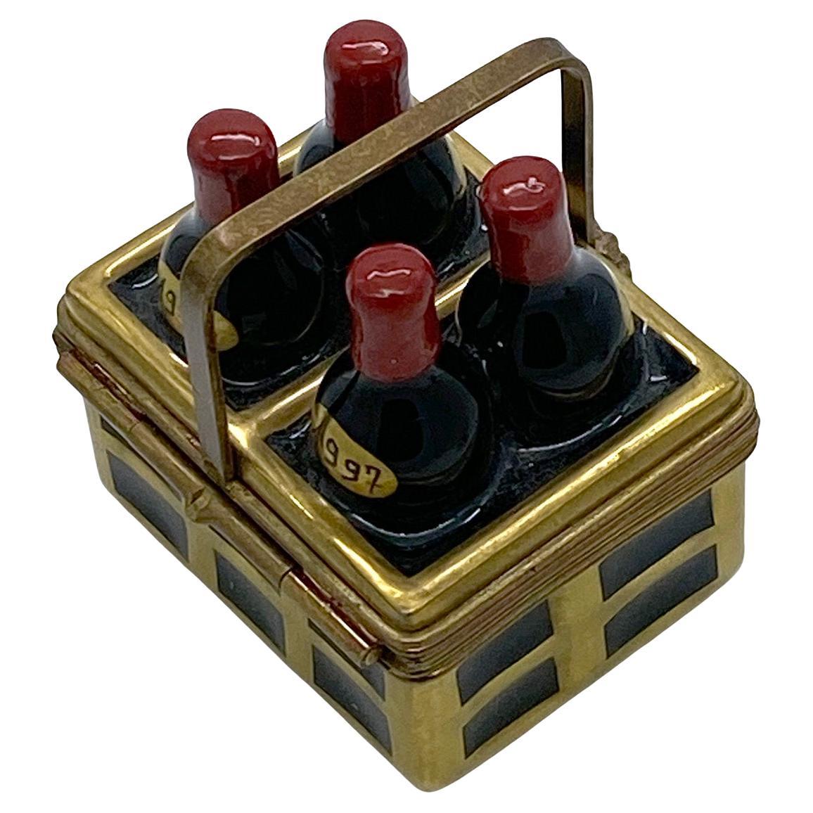This is a hand painted Limoges trinket box with wine bottles in a crate and a brass handle. There are four 1997 wine bottles in a crate on the lid. It has a painted corkscrew inside of the box. On the bottom is 