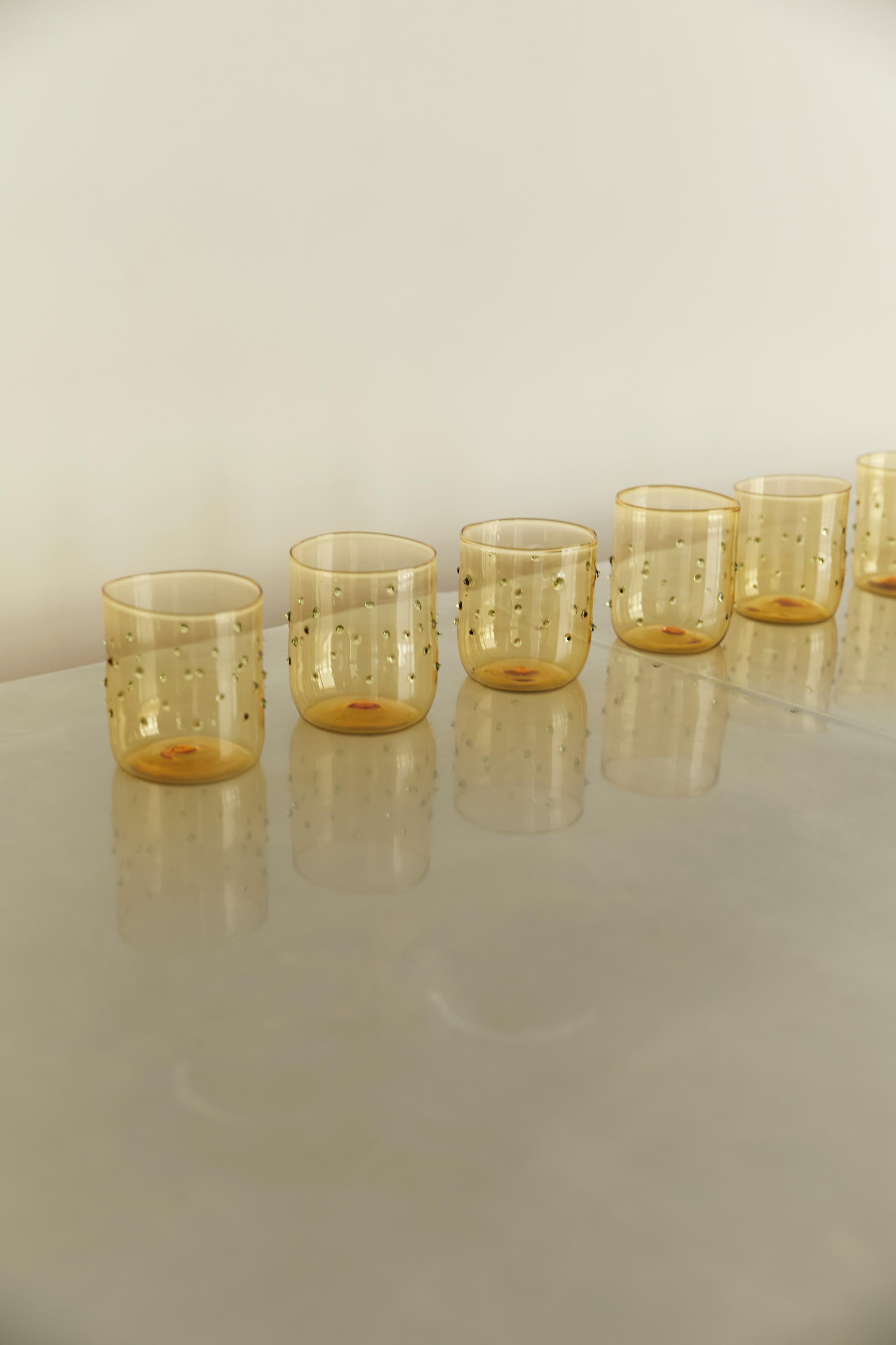Handmade artisan glasses made in Spain with the traditional technique of blown glass but with contemporary modern design. Using tinted yellow glass with green detailed dots, this Limoncello glasses are created. The handmade craft makes each piece