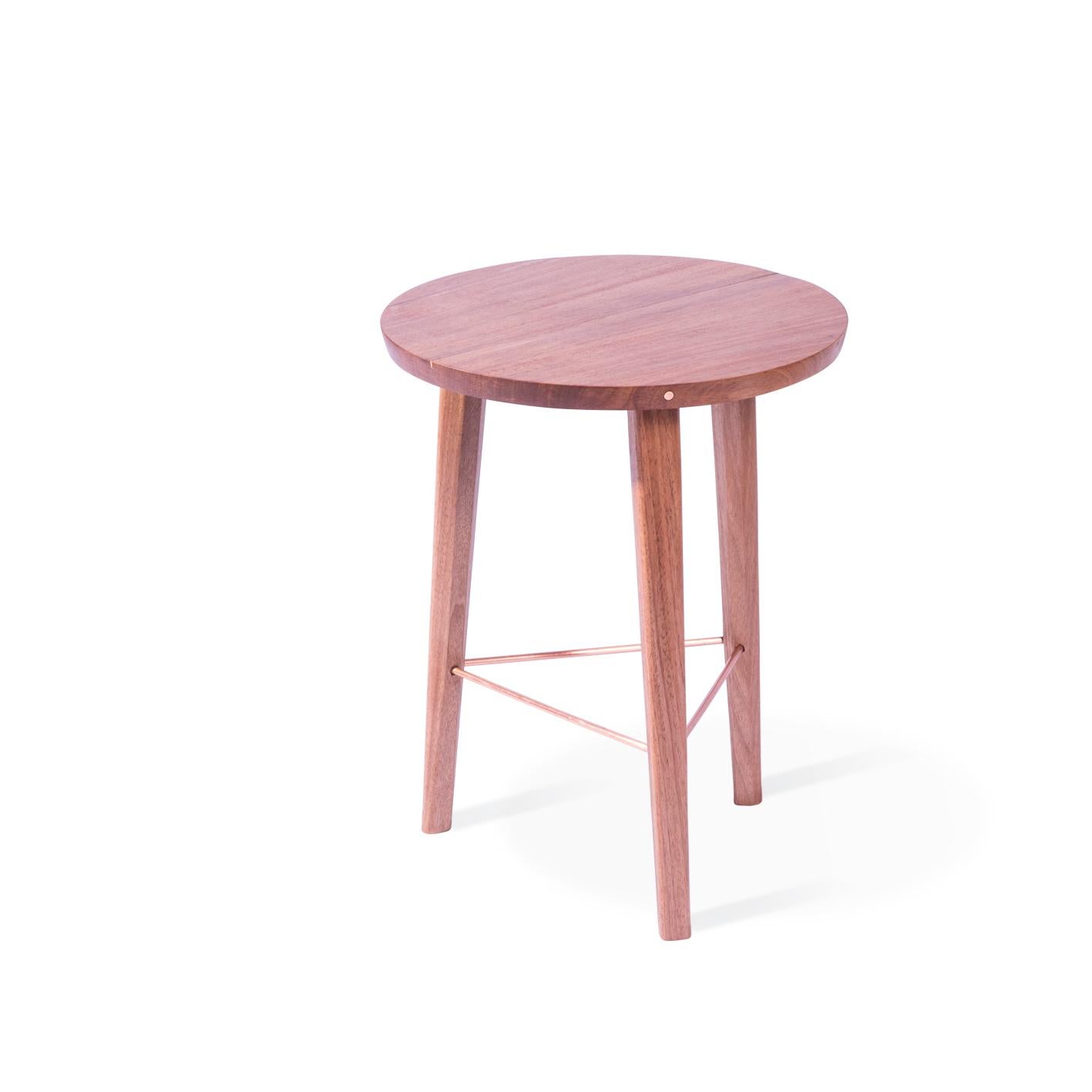 A clean and simple design for a traditional three-legged stool which gives it a thoroughly modern appeal through its copper details and slender appearance. The copper line on the seat marks the join in the wood and as such is different on each