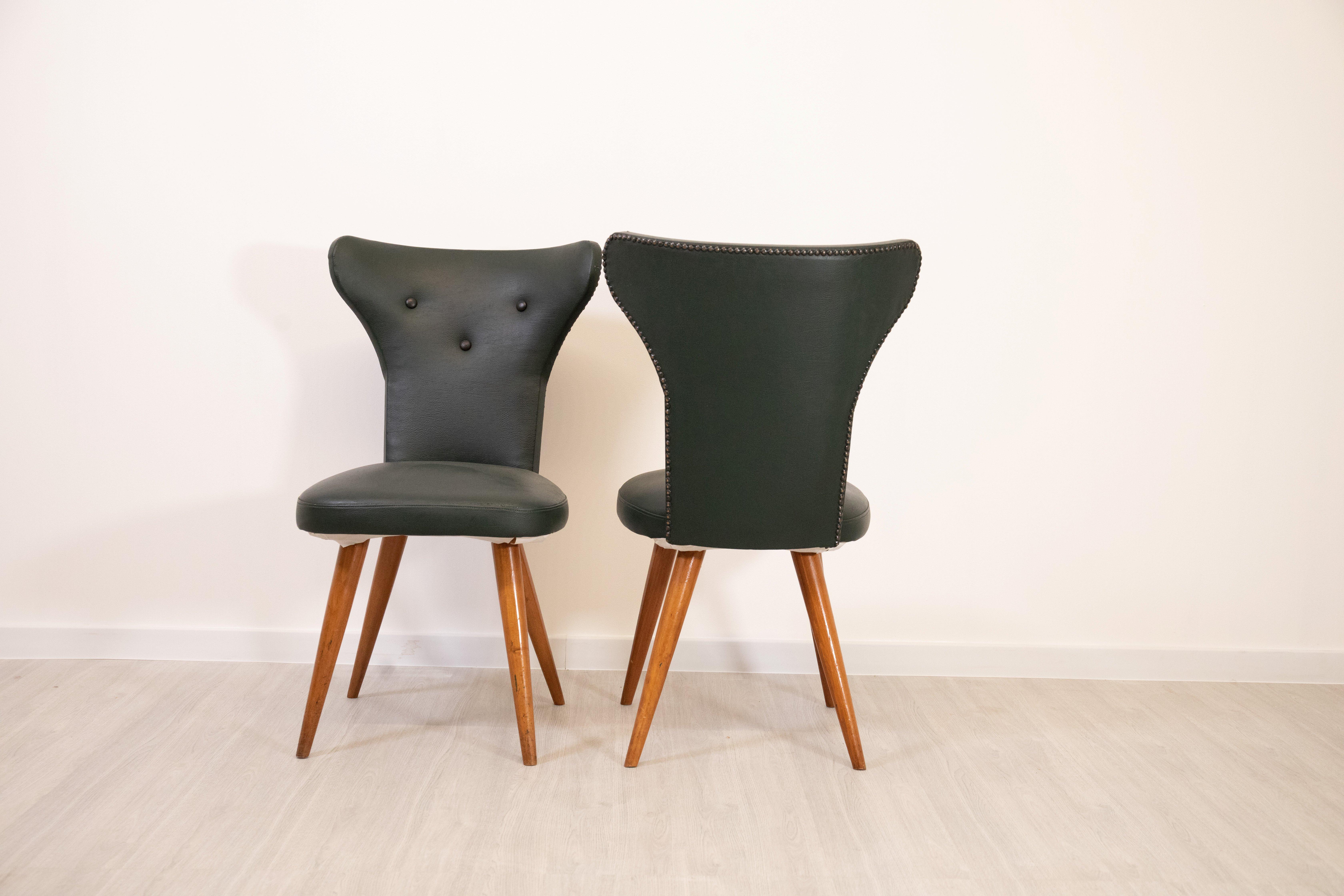 Elegant pair of chairs attributed to Lina Bo Bardi and Carlo Pagani, made in Italy in the 1960s. Solid wood frame with black skai upholstered seat and back, with sinuous and distinctive lines of modernist design of the time. The sloping legs and