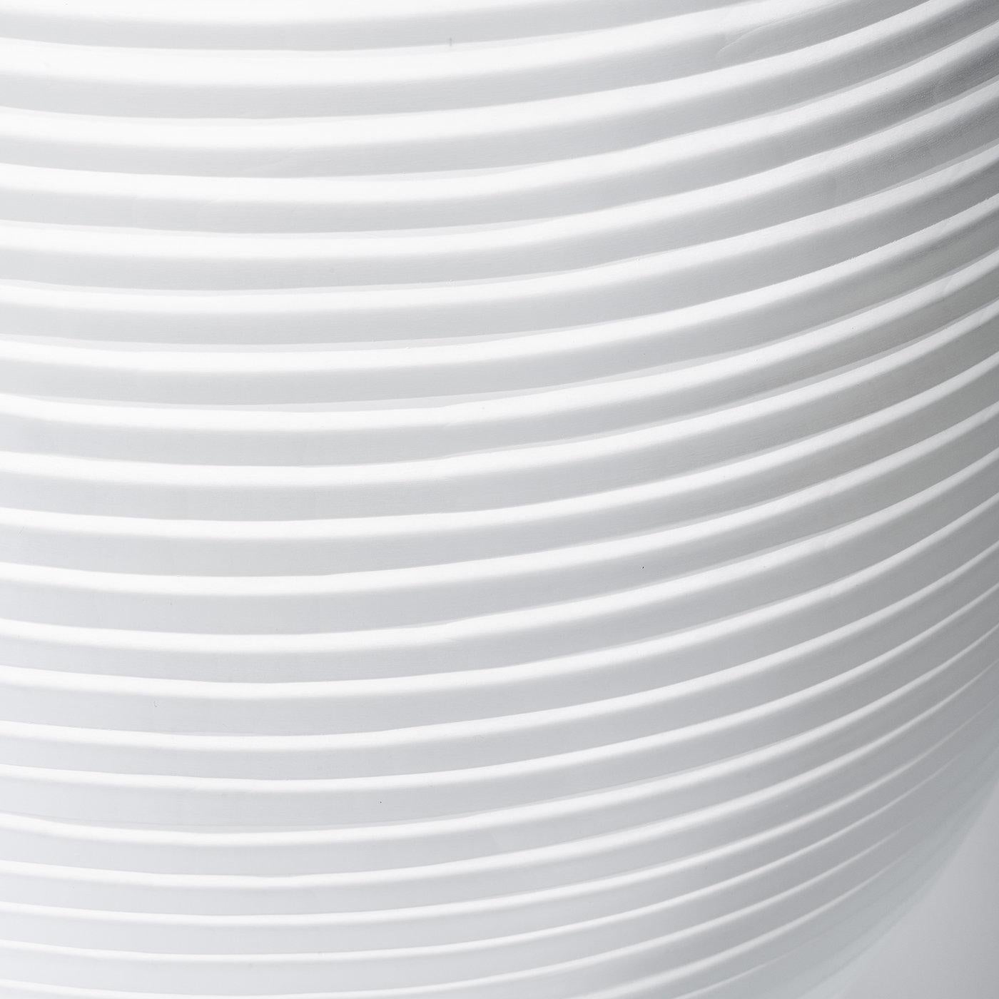 Les vases Linae sont une série de pots circulaires réalisés en verre épais soufflé de Murano dans un ton uni. Disponible en trois formes et motifs différents, le vase le plus haut, le Linae Large, présente des incisions horizontales créant un effet
