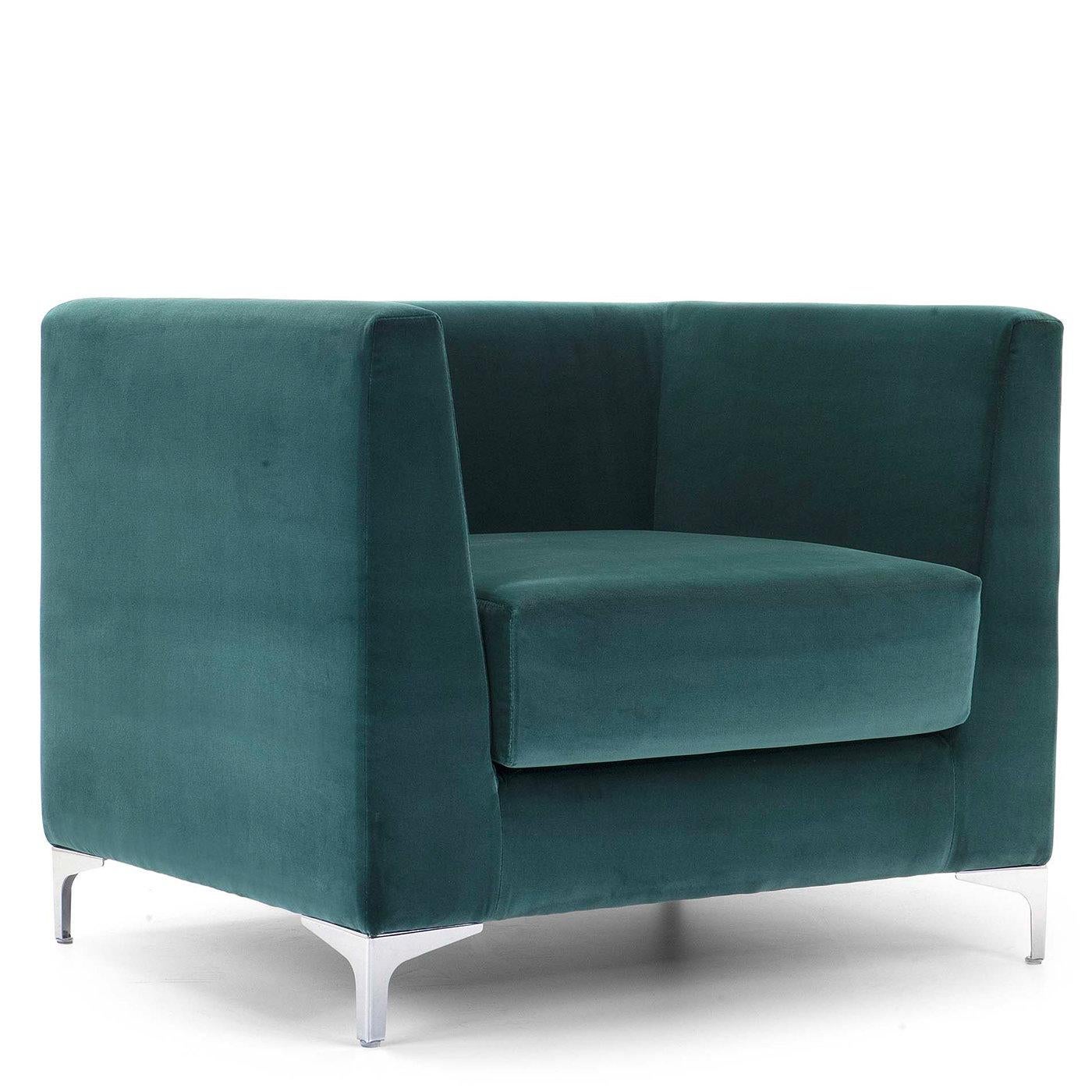 This armchair is luxurious, stylish, and relaxing all at once. Inspired by the classic mid-century cube shape, it boasts an architectural look in a comfortably proportioned size. The lofty silhouette is wrapped in a superb blue-green dacron