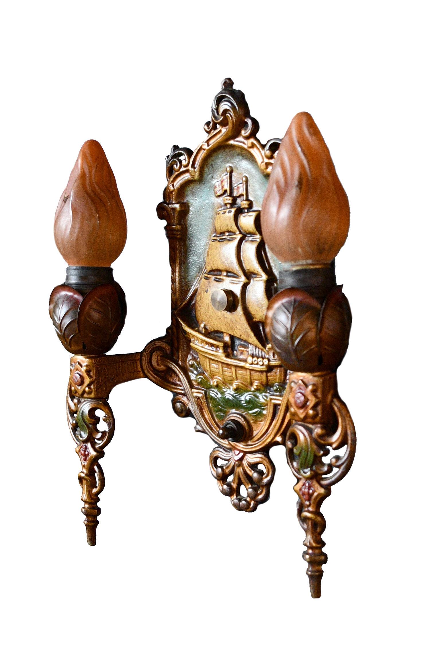 These sconces are in amazing condition for their age and will be a statement piece to any living space. A large central ship on the backplate is set in an ornate gold frame. The base of the body has a turn switch and fanning out from it many