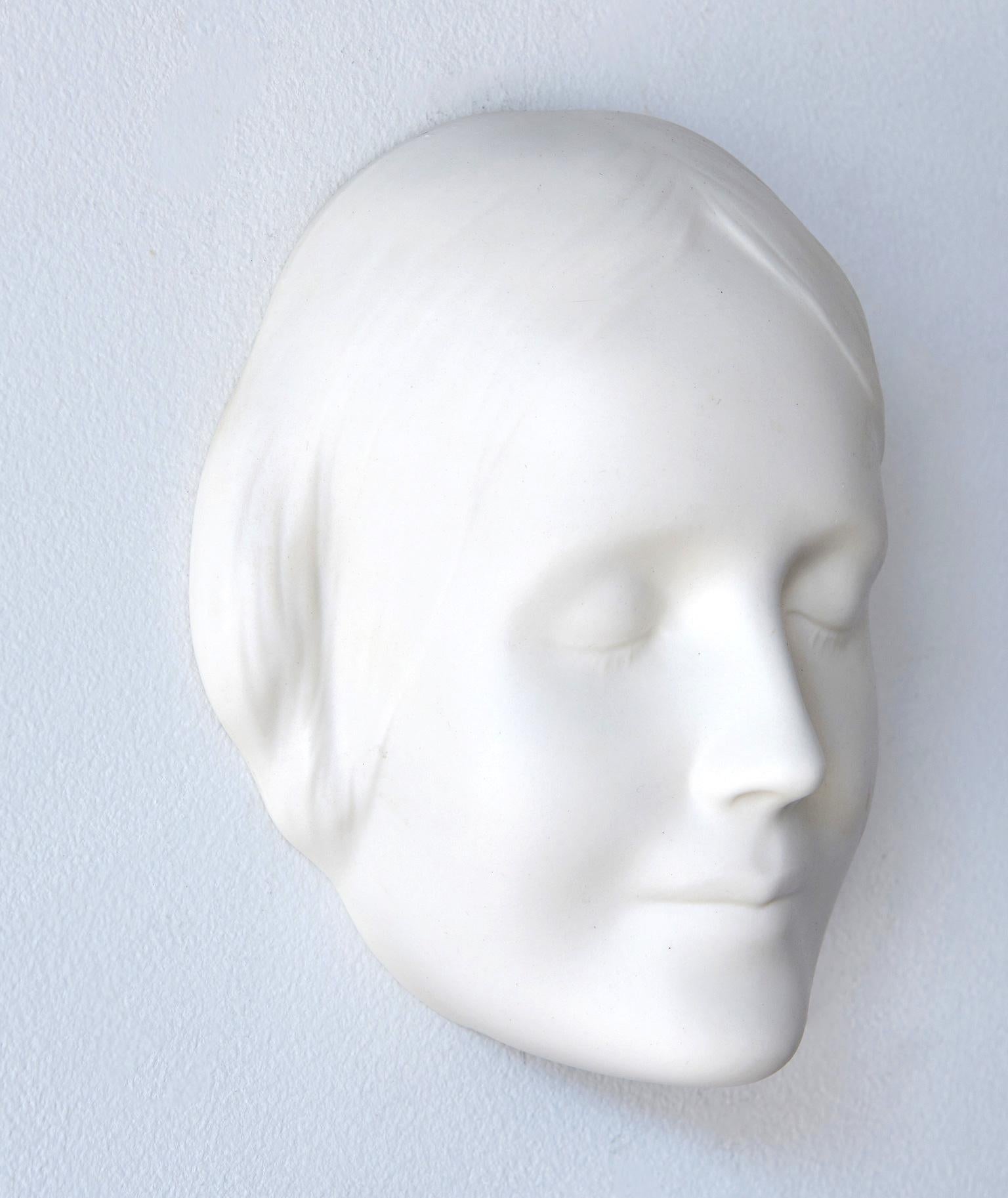 This bisque porcelain wall mask is of an anonymous woman who, in the 1880s, committed suicide by drowning by jumping into the Seine river in Paris. Her identity was never discovered, but her enigmatic facial expression and innocent, peaceful beauty