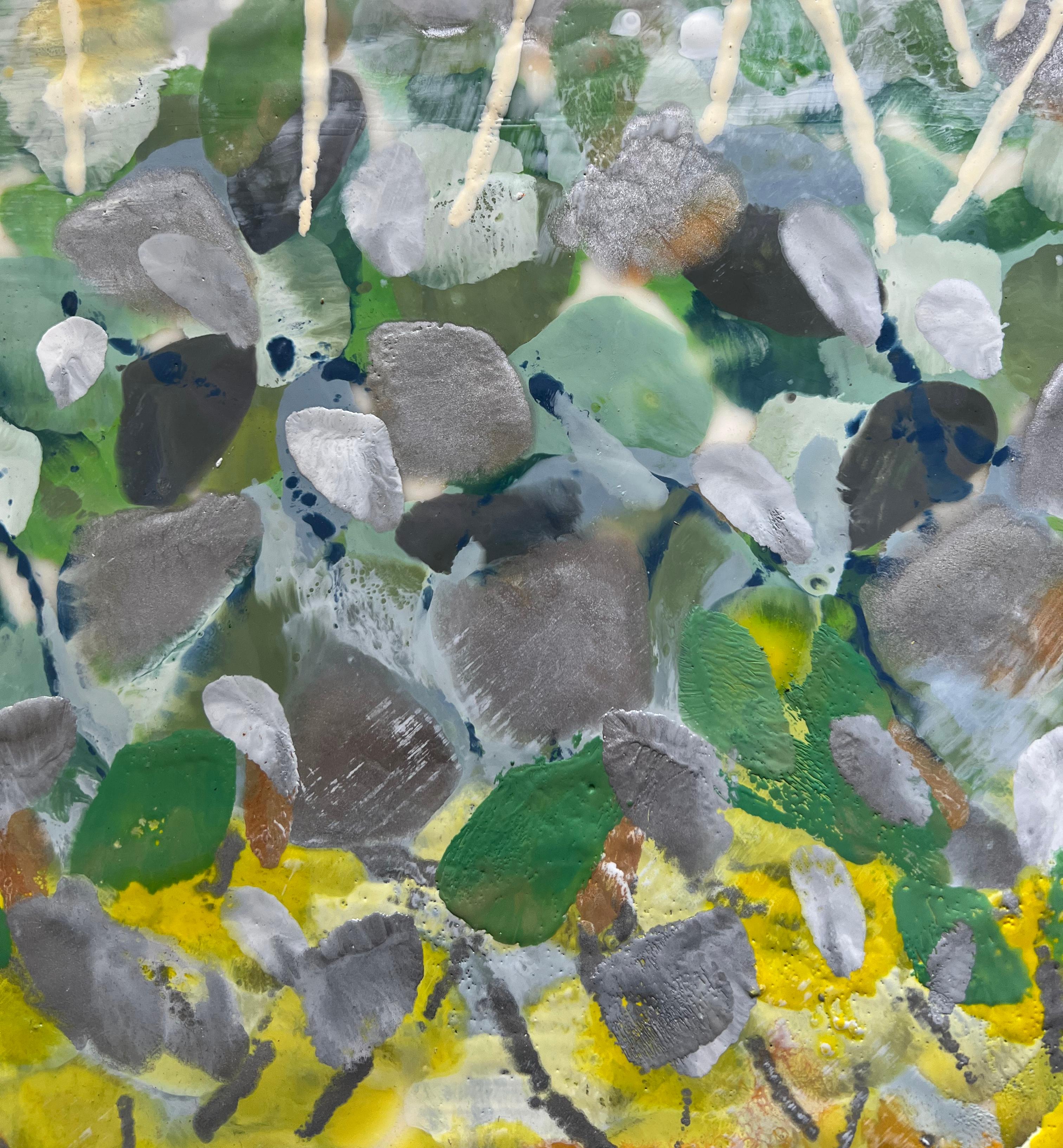 This abstract floral encaustic painting by artist Linda Bigness features a light and colorful palette of green,  yellow, and muted blue and purple. Thick layers of paint are assembled to create a sense of a floral garden, with yellow floral stems