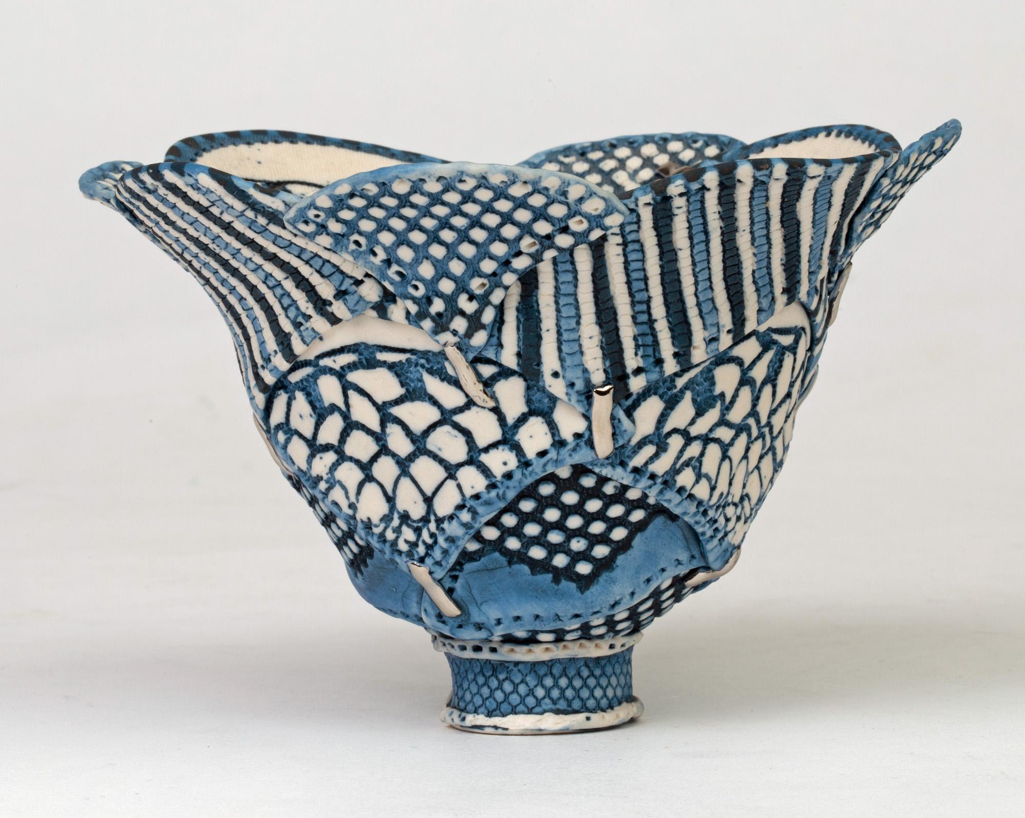 From an extensive collection of studio pottery is this stylish and unusual porcelain bowl in a textile inspired pattern by Linda Chew. The bowl is made of petal like overlapping sections each in varying blue patterns on a white ground joined by