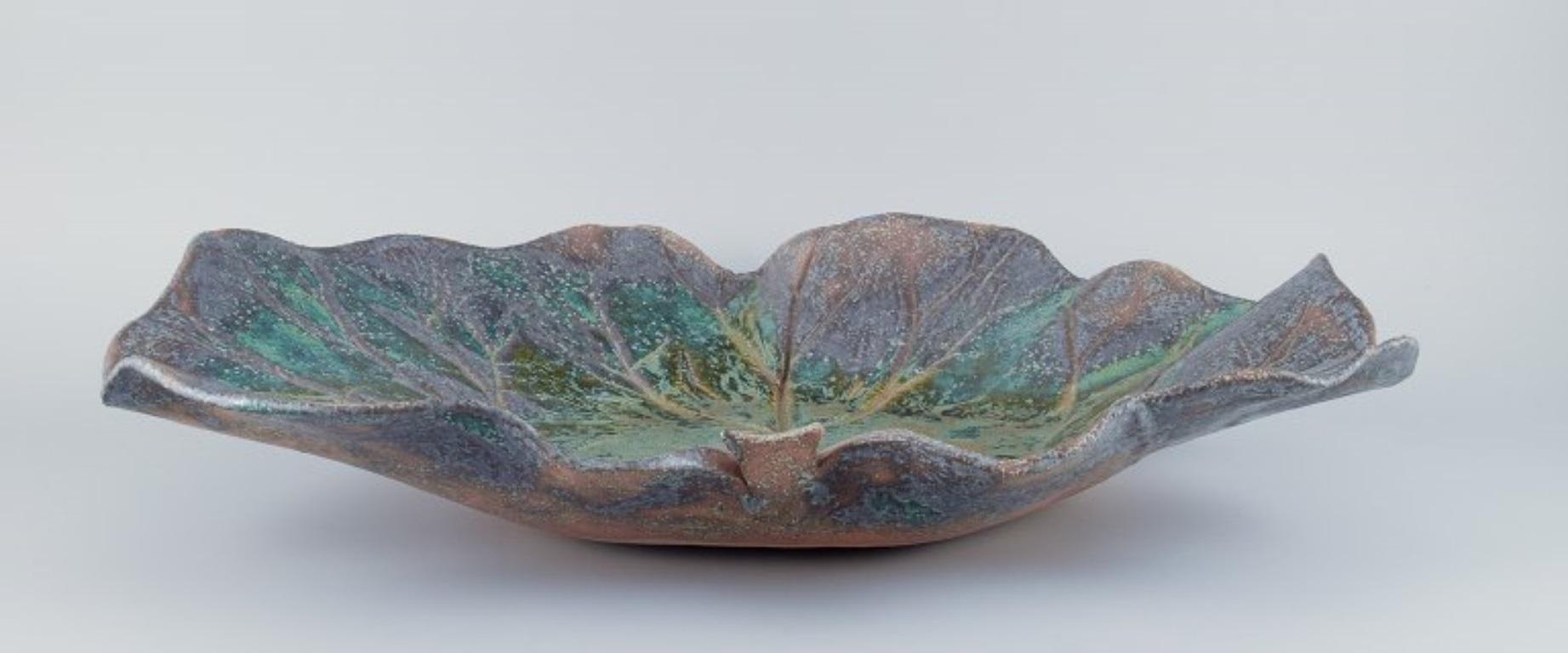 Linda Mathison, Sweden. Colossal leaf-shaped ceramic bowl with glaze in violet, green, and brown hues. High-quality contemporary ceramics.
Signed on the front and back. LM 04
Dated 2004.
Perfect condition.
Dimensions: D 58.0 cm x H 48.5 cm x D 10.0