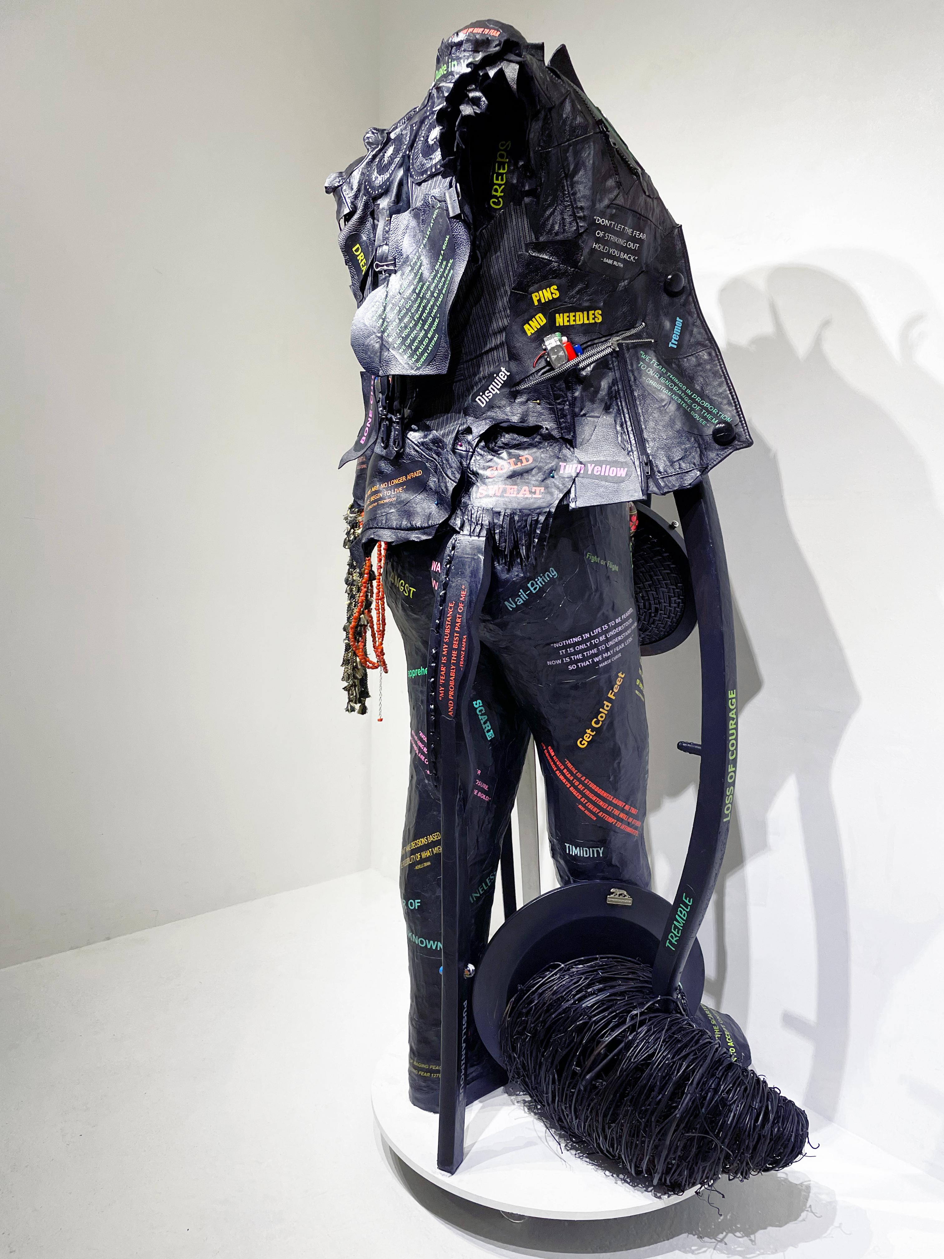 Linda Stein, Guerriera che porta la pace: Affrontare la paura 1279 - Scultura contemporanea femminista a tecnica mista nera e colorata 

Questa scultura d'arte contemporanea indipendente indossa un gilet ed è ricoperta di citazioni che affrontano