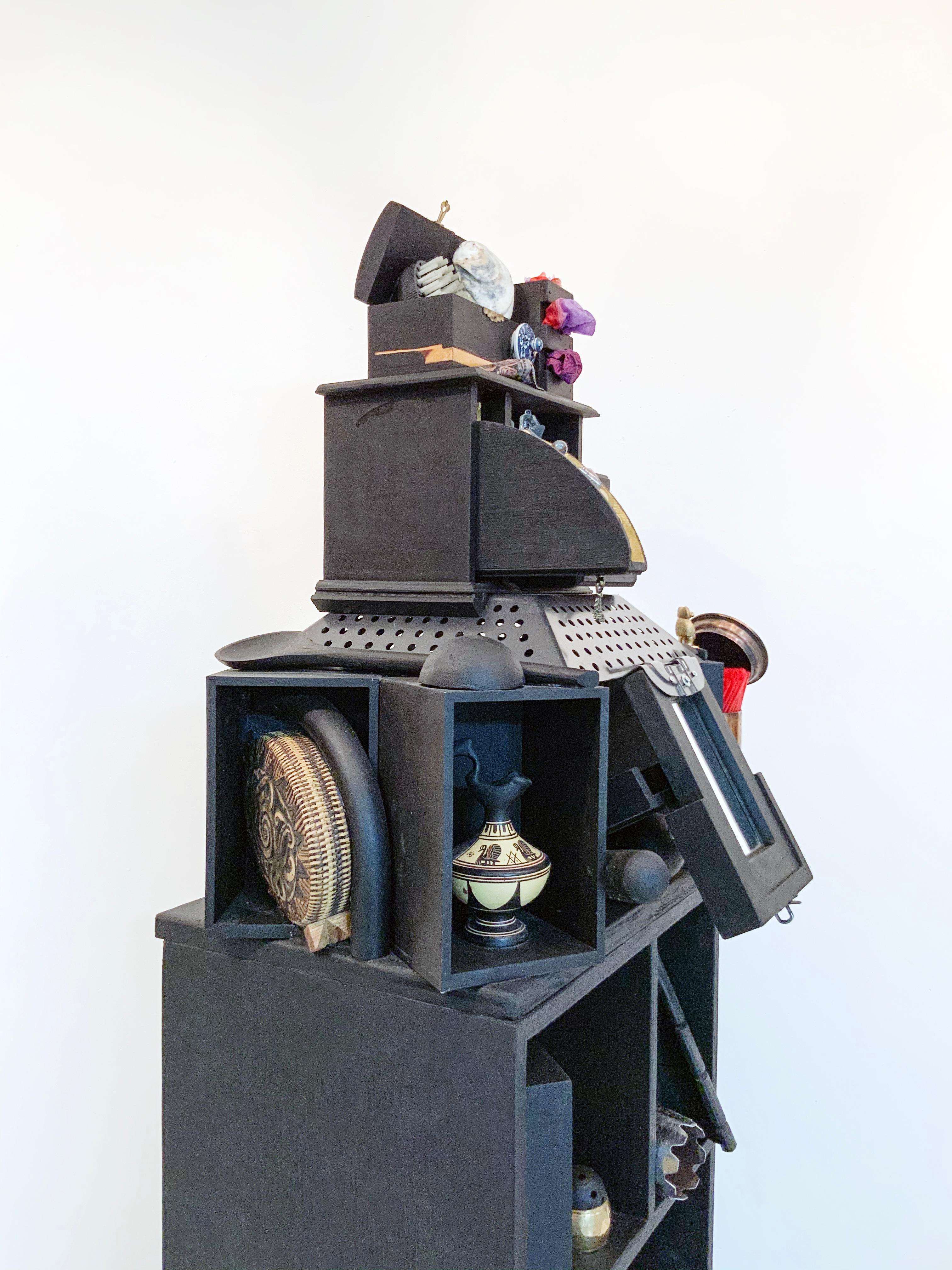 Esta obra de la serie Desplazamiento del Hogar de Linda Stein se inspira en la tradición de las wunderkammer/armarios de curiosidades para poner de relieve el desplazamiento global y la memoria traumática de los emigrantes y refugiados de todo el