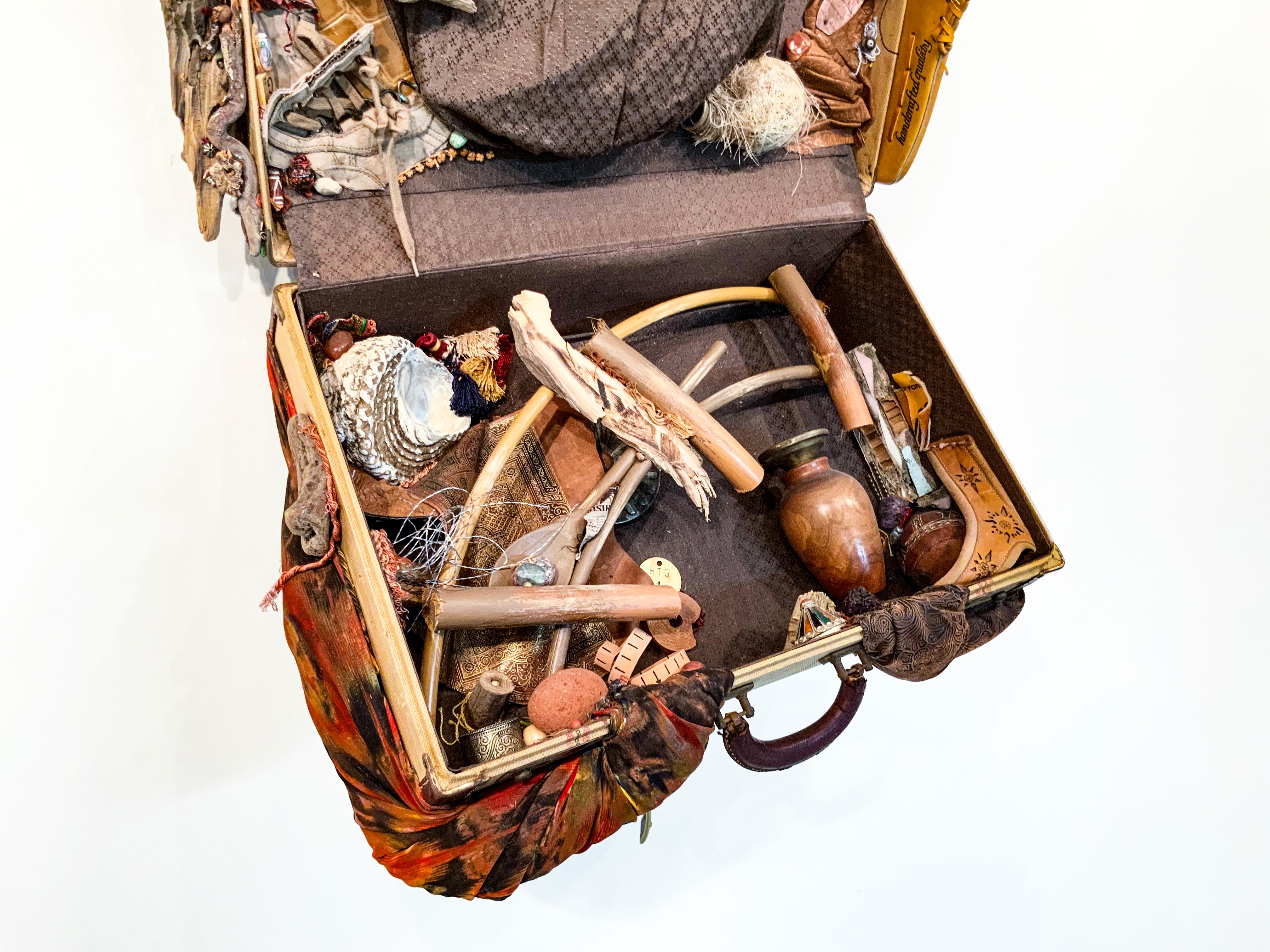 This work from Linda Stein's Displacement From Home series draws from the tradition of wunderkammer/cabinets of curiosities to highlight the global displacement and traumatic memory of migrants and refugees around the world. 

The sculpture is made