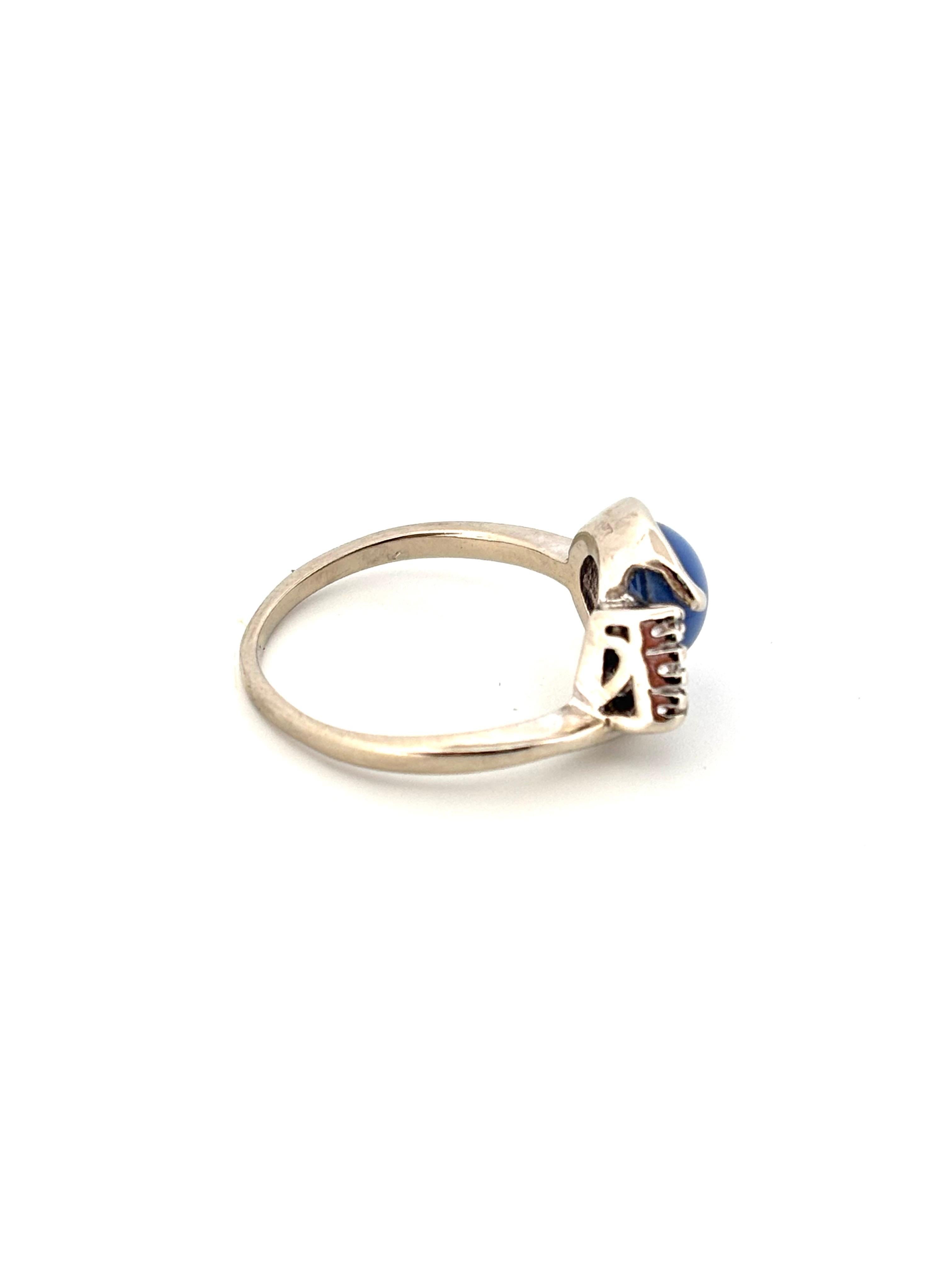 Dieser elegante Vintage-Ring präsentiert einen auffälligen Linde-Sternsaphir-Cabochon, gefasst in 14 Karat Weißgold. Der synthetische Saphir weist einen lebhaften blauen Farbton auf, der durch den charakteristischen sechsstrahligen Stern