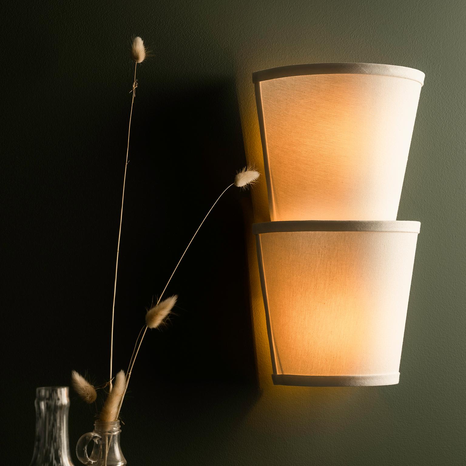 A smaller sibling to our best-selling Linden 2-Sconce - 23.5in, this modern linen wall fixture reinterprets classic art deco geometry. Position the flared end upwards or downwards for a soft dramatic glow that is both compelling and