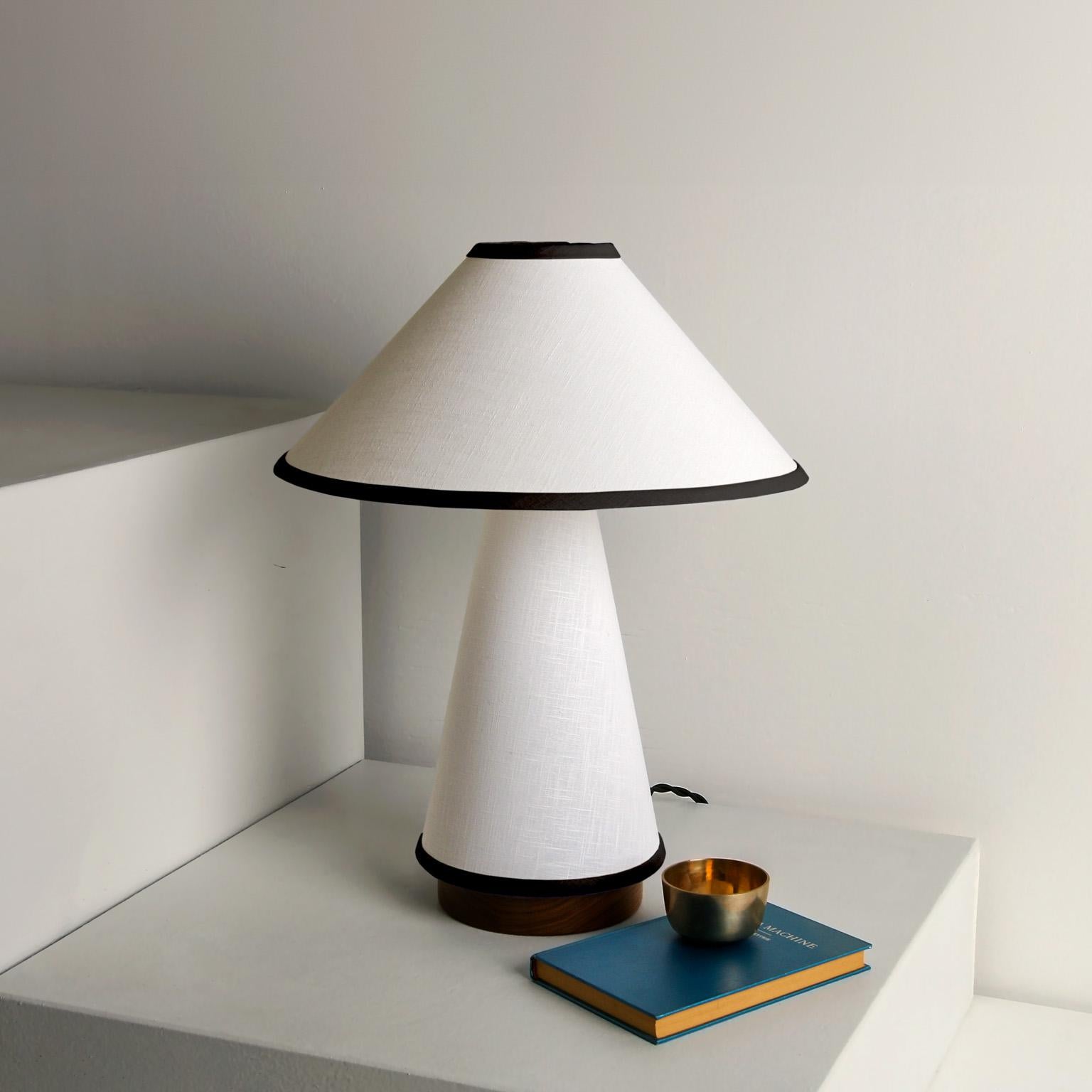 Notre lampe de table contemporaine Linden est maintenant disponible dans une hauteur plus courte de 20,5 pouces avec un abat-jour de 16 pouces de diamètre. Cette lampe minimaliste est dotée d'un tissu en lin, d'une base en bois dur et de détails en