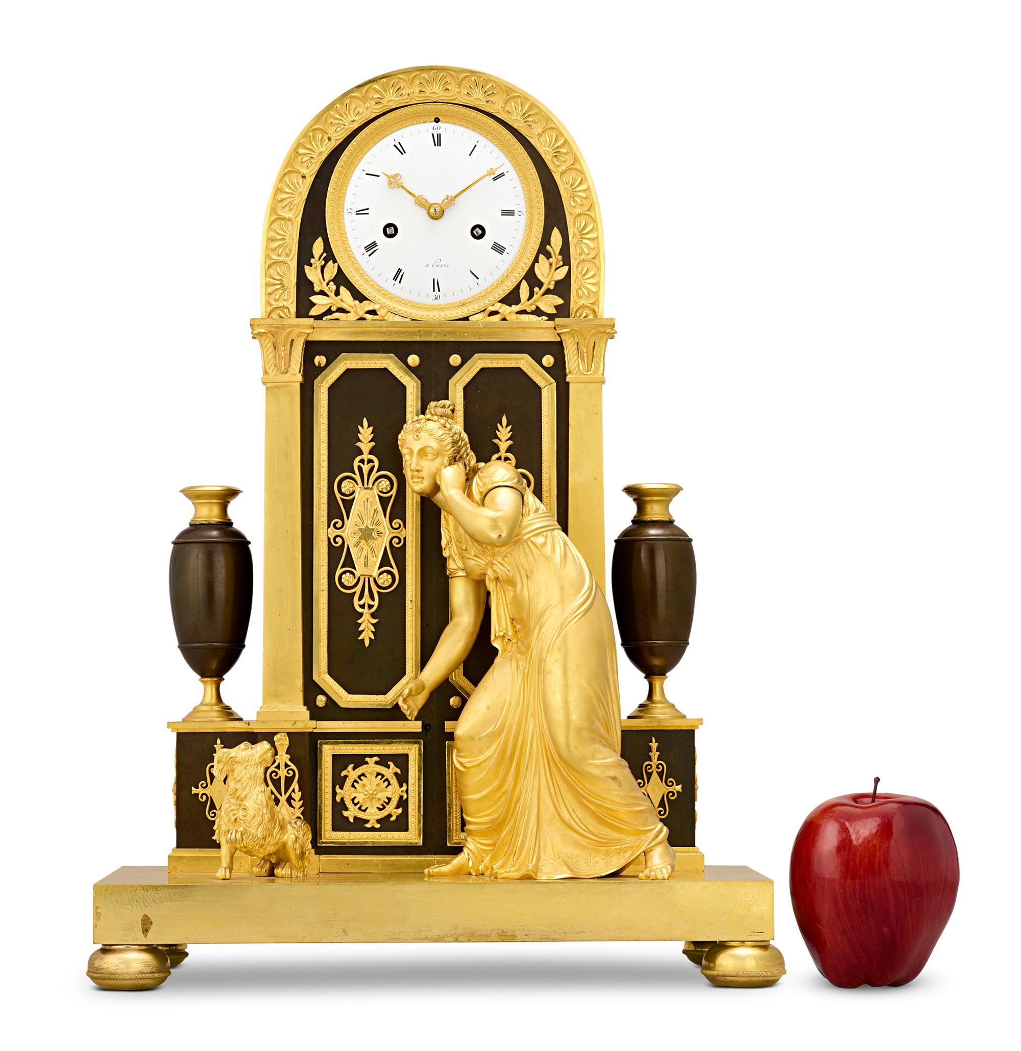 “L'indiscrète” French Empire Mantel Clock
Claude Galle
Circa 1810

This splendid French Empire mantel clock, crafted in patinated and gilt bronze, displays the iconic “L’Indiscrète,” depicting a young woman eavesdropping at a door with her loyal