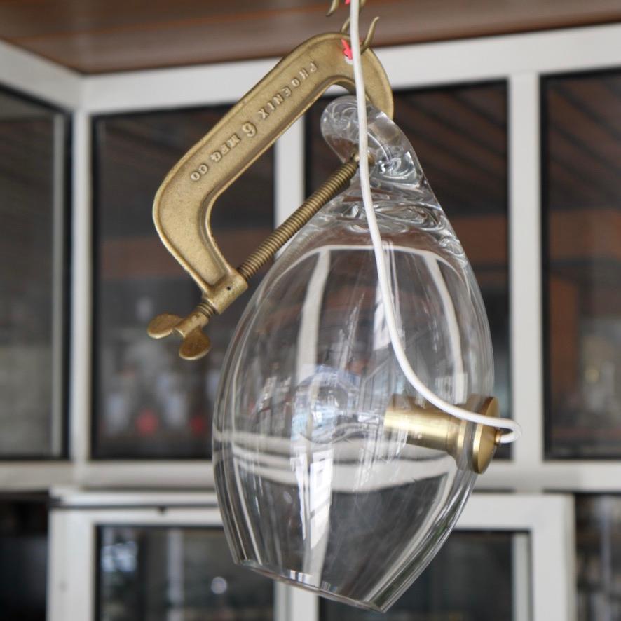 Here is one of Linsey Adelman's more whimsical designs, the Clamp Light. Hanging off an 8' chain and made of clear handblown glass held by a vintage found brushed brass industrial clamp.

 Lindsey Adelman lives and works in her hometown of New