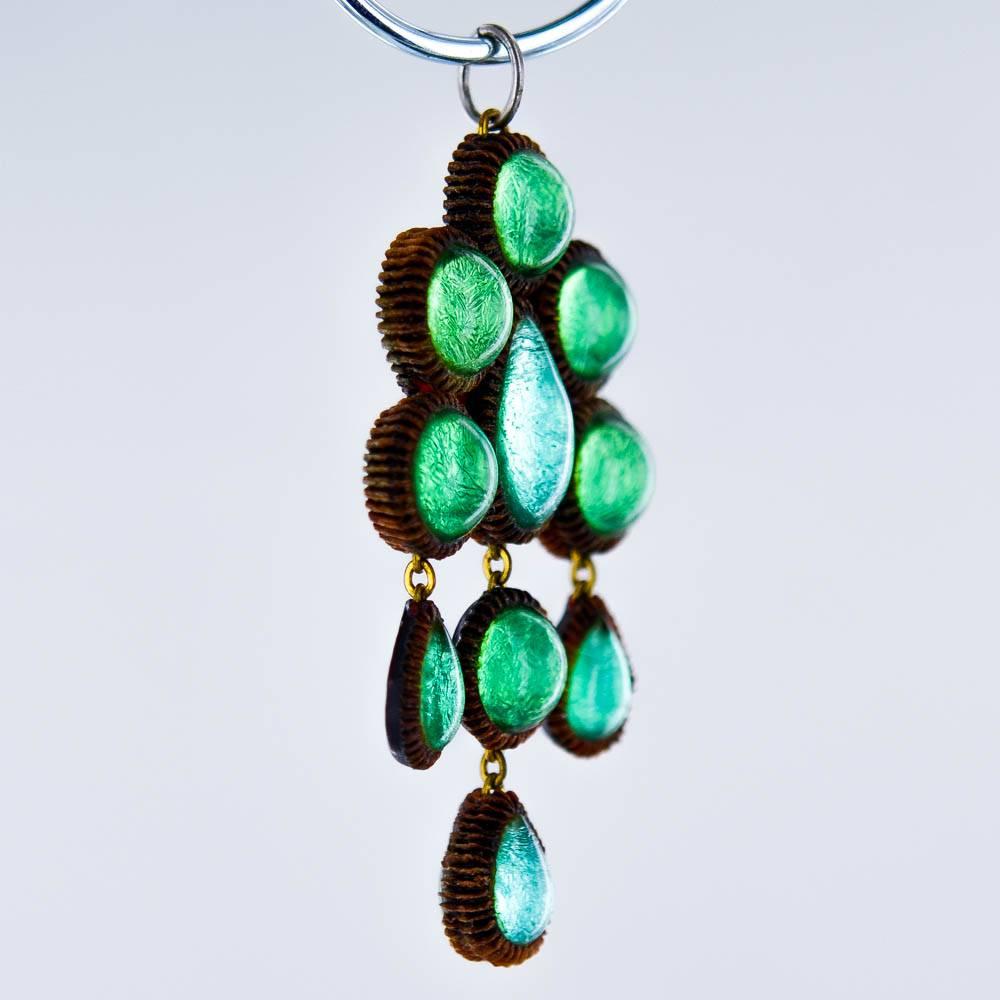 Beautiful and original pendant in Talosel made by the French artist Line Vautrin in the 1960s. A green and turquoise colors are covering a red transparent part. Each part is attached using a golden chain.