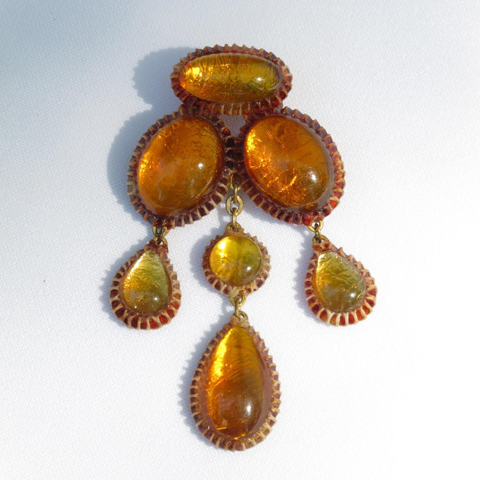 This stunning and rare dangling brooch was made in the 1970s by one of Line Vautrin's students. The brown Talosel framing boasts an encrusted geometric form with honey amber resin cabochons on a silver foil background. The brooch has a security