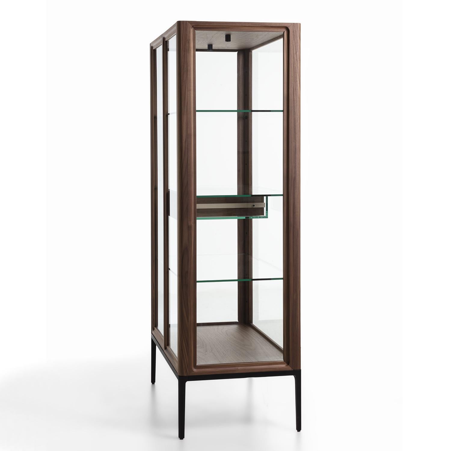 Cabinet Linea with structure in solid walnut, with clear glass
doors and clear glass shelves. With metal base in matt black finish.
Intside drawer in solid walnut with rails in solid maple in natural finish. 
The drawer including 2 trays in solid