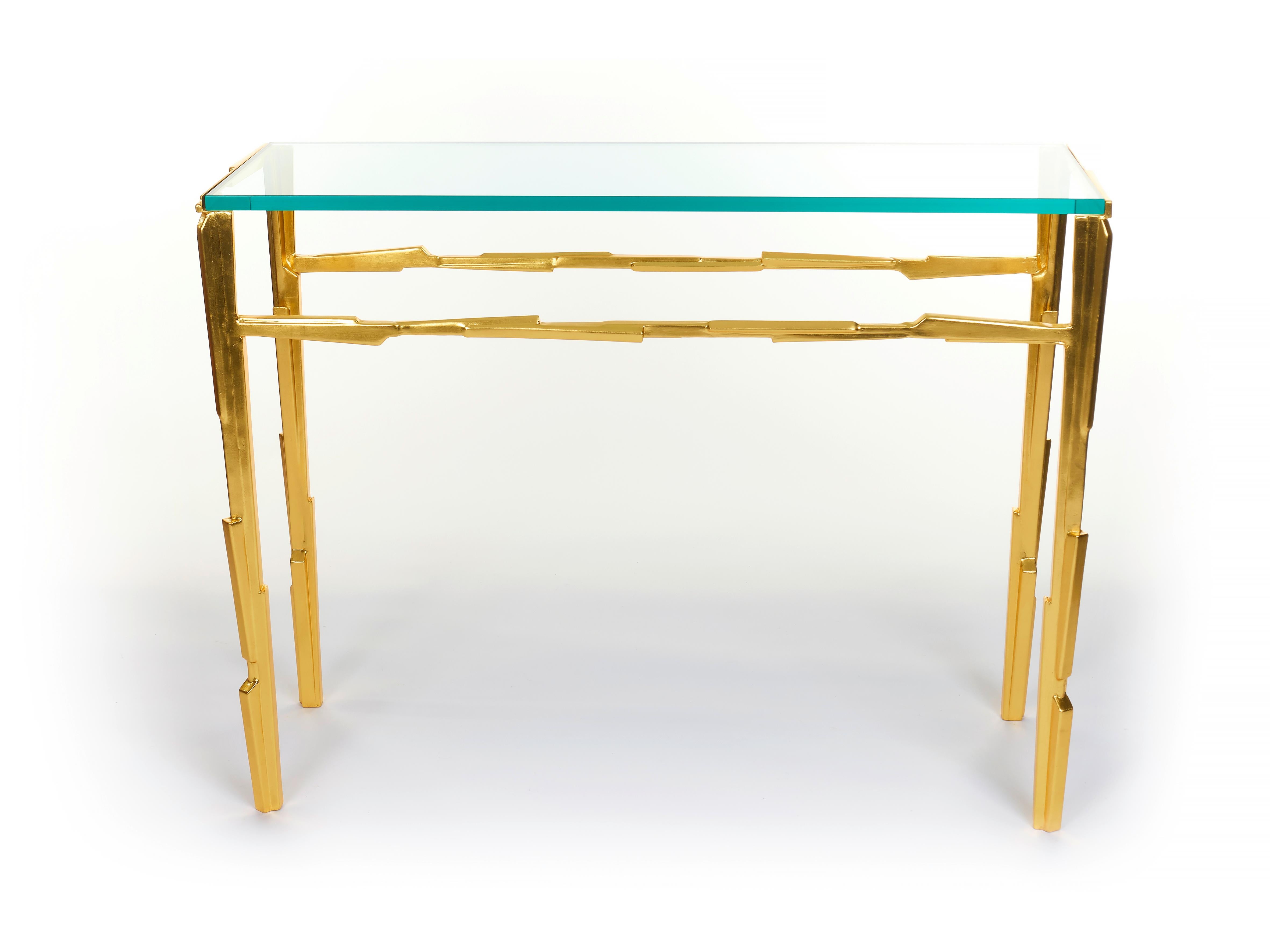 Linea Console table gilded with 23K Yellow Gold and clear glass top. Fragments of metal, shaped and assembled in line with a secret sense of order. As our furniture is hand-crafted, this piece can be custom made to any  size or proportion to suit