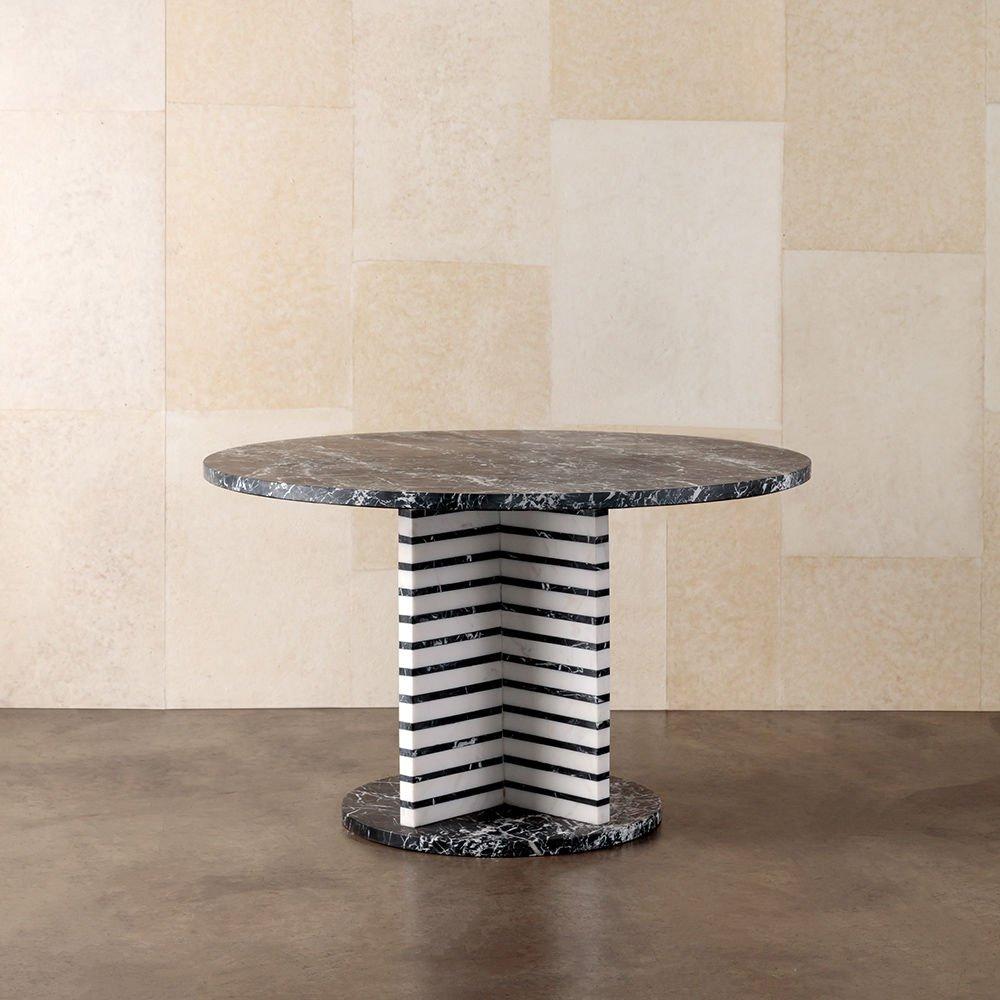 A confluence of mixed-marble and architectural tectonic form, the lineage dining table exemplifies the modern dualities of art and functionality. This sculptural dining table features alternating layers of natural Nero Marquina and white marble with