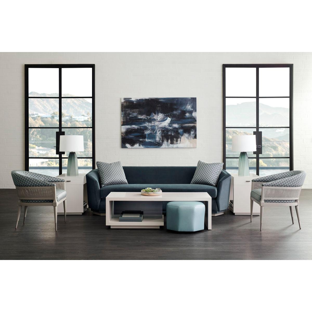 Bold in form and perspective, this unmistakable cocktail table takes linearism to the max. A Winter Haze finish highlights its signature shape while a smoked, gray glass insert panel distinguishes the back. An open area provides room for storage and